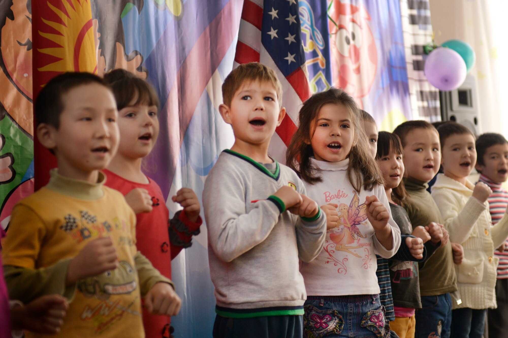 Local children from the Leninskoe Village Kindergarten sing English songs during the dedication ceremony to show their appreciation to the American Airmen who helped in the renovation of the school’s roof in Leninskoe, Kyrgyzstan, Dec. 6, 2013. The roof was fully renovated in less than a month and was the final touch in the complete overhaul of the school. (U.S. Air Force photo/Staff Sgt. Travis Edwards)