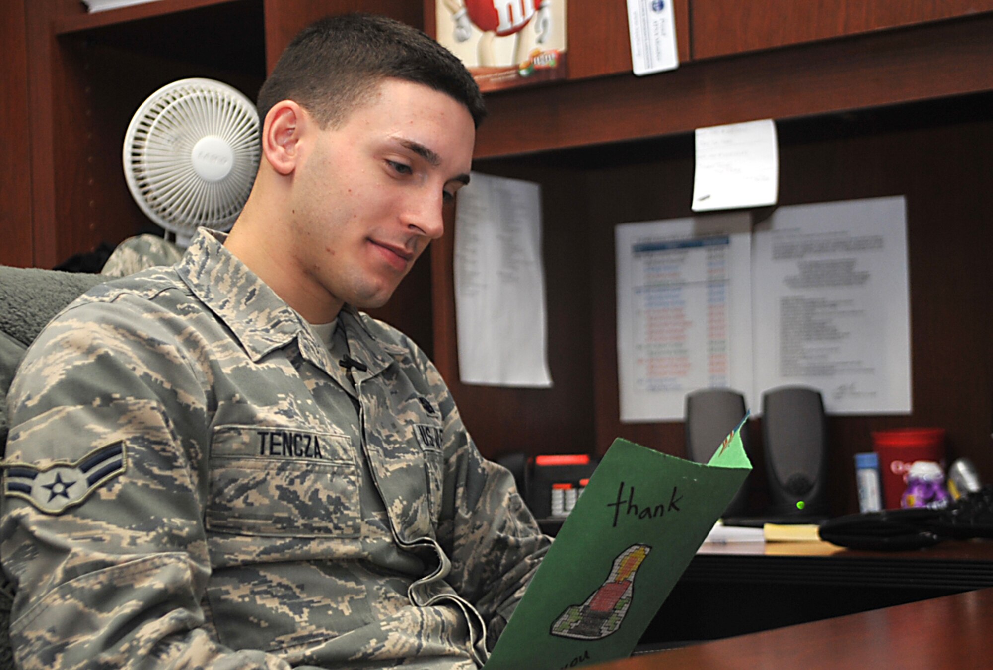 Airman 1st Class Mathew Tencza, 51st Mission Support Group knowledge operations manager, reads a holiday greeting card from his Operation Sweet Treat goodie bag at Osan Air Base, Republic of Korea, Dec. 10, 2013. Tencza has been at Osan since May, and said he appreciates the volunteers that made his goodie bag thinking of him while he is away from his family during the holidays. (U.S. Air Force photo/Airman 1st Class Ashley J. Thum)