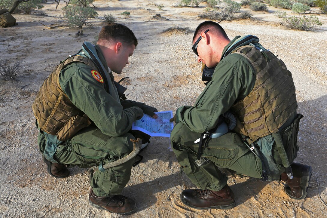 Marine Corps Capts. Phillip A. Smith, left, and Stephen W. White, request support during a Tactical Recovery of Aircraft and Personnel while participating in exercise Steel Knight 2014 in Yuma, Ariz., Dec. 9, 2013. Smith and White, pilots, are assigned to Marine Attack Squadron 211, Marine Aircraft Group 13, 3rd Marine Aircraft Wing. Steel Knight is a large scale combined arms, live-fire exercise integrating ground troops in preparation for employment as a maneuver force across a range of military operations.