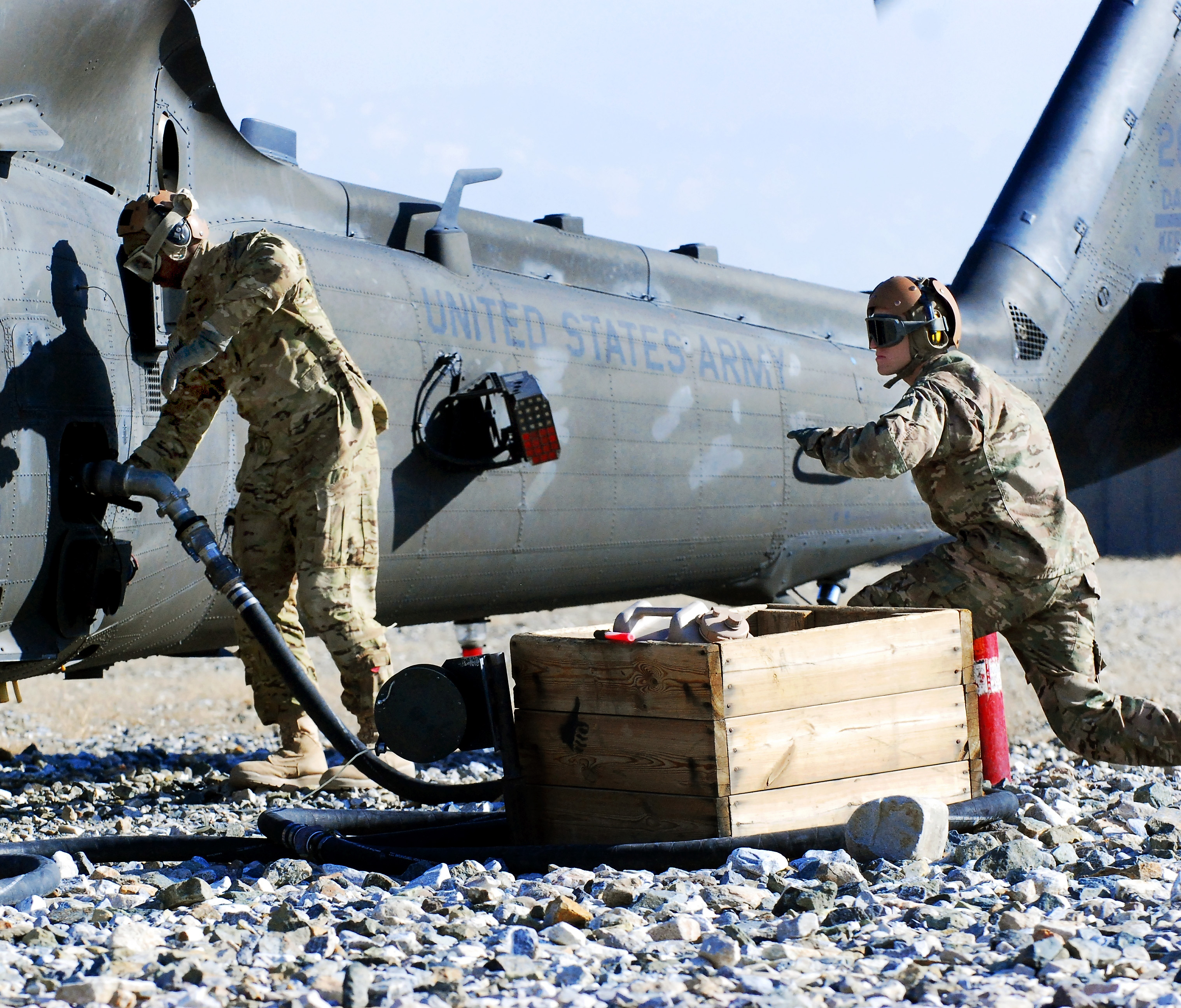 U.S. Army Spcs. Russell King, left, and Eric Daniels signal to a fuel