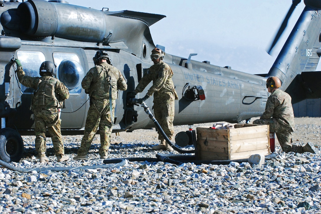 U.S. Army crew chiefs, left, observe as U.S. Army Spcs. Russell King ...