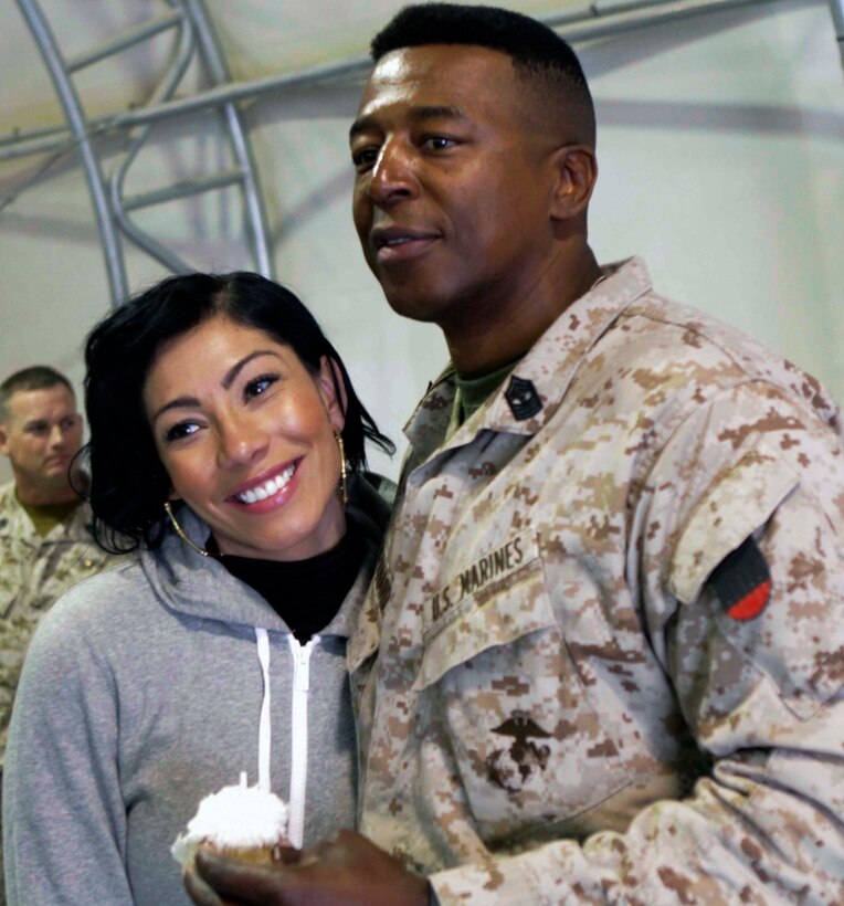 Bridget Kelley, a Grammy-winning songwriter and singer, poses with U.S. Marine Master Gunnery Sgt. Allen Bernard during the annual USO holiday tour on Camp Leatherneck, Afghanistan, Dec. 10, 2013. 
