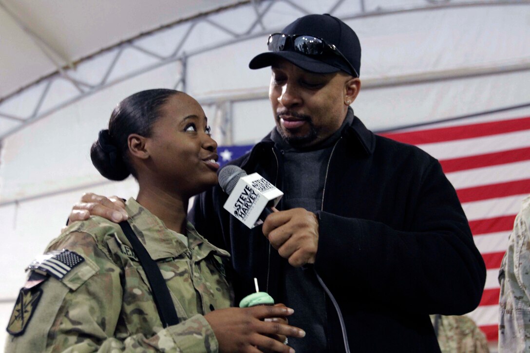 Thomas Miles, co-host of the "Steve Harvey Show," speaks with a U.S. Army soldier during the annual USO holiday visit to Camp Leatherneck, Afghanistan, Dec. 10, 2013. 