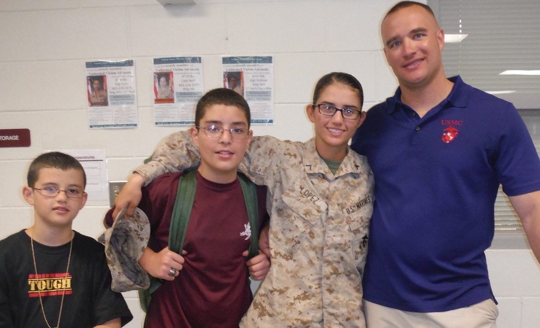 U.S. Marine Corps Pfc. Jessica Lopez and U.S. Marine Corps Staff Sgt. Daniel Barker, right, take a moment to celebrate Lopez’s accomplishment of earning the eagle, globe and anchor during Family Day on Aug. 15, 2013. Her stepfather, Barker, is currently the staff noncommissioned officer-in-charge of Recruiting Substation Tri-County. Lopez is currently enrolled at her Military Occupational Specialty school in Pensacola, Fla., where upon successful completion of her course, she will become an air traffic controller. (Courtesy Photo).