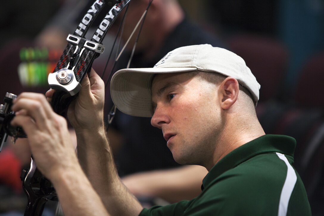 Brad Vande Hei, a disabled Marine Veteran, inspects his compound bow during the first day of an archery camp held by the Wounded Warrior Regiment Dec. 4, 2013, in Anniston, Ala. The Marines and sailor trained approximately eight hours a day during the four-day camp. The camp is held annually to help members of the regiment cope with their disabilities and hone their archery skills. (Marine Corps photo by Lance Cpl. Dylan Bowyer/ Released)
