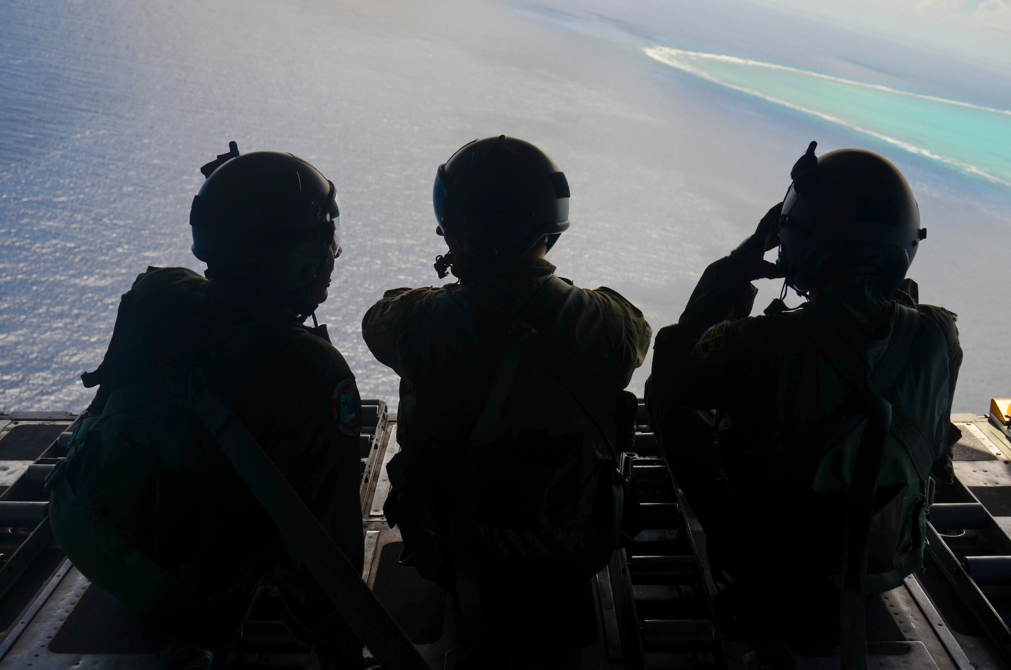 Loadmasters from the 36th Airlift Squadron from Yokota Air Base, Japan, and Airmen from the 36th Wing sit on the ramp of a C-130 Hercules during an Operation Christmas Drop mission over the Pacific Ocean Dec. 11, 2013. Every December, C-130 Hercules aircrews from the 374th Airlift Wing at Yokota AB partner with the 36th Wing at Andersen AFB to airlift food, supplies and toys to islanders throughout Micronesia. (U.S. Air Force photo by Senior Airman Marianique Santos/Released)