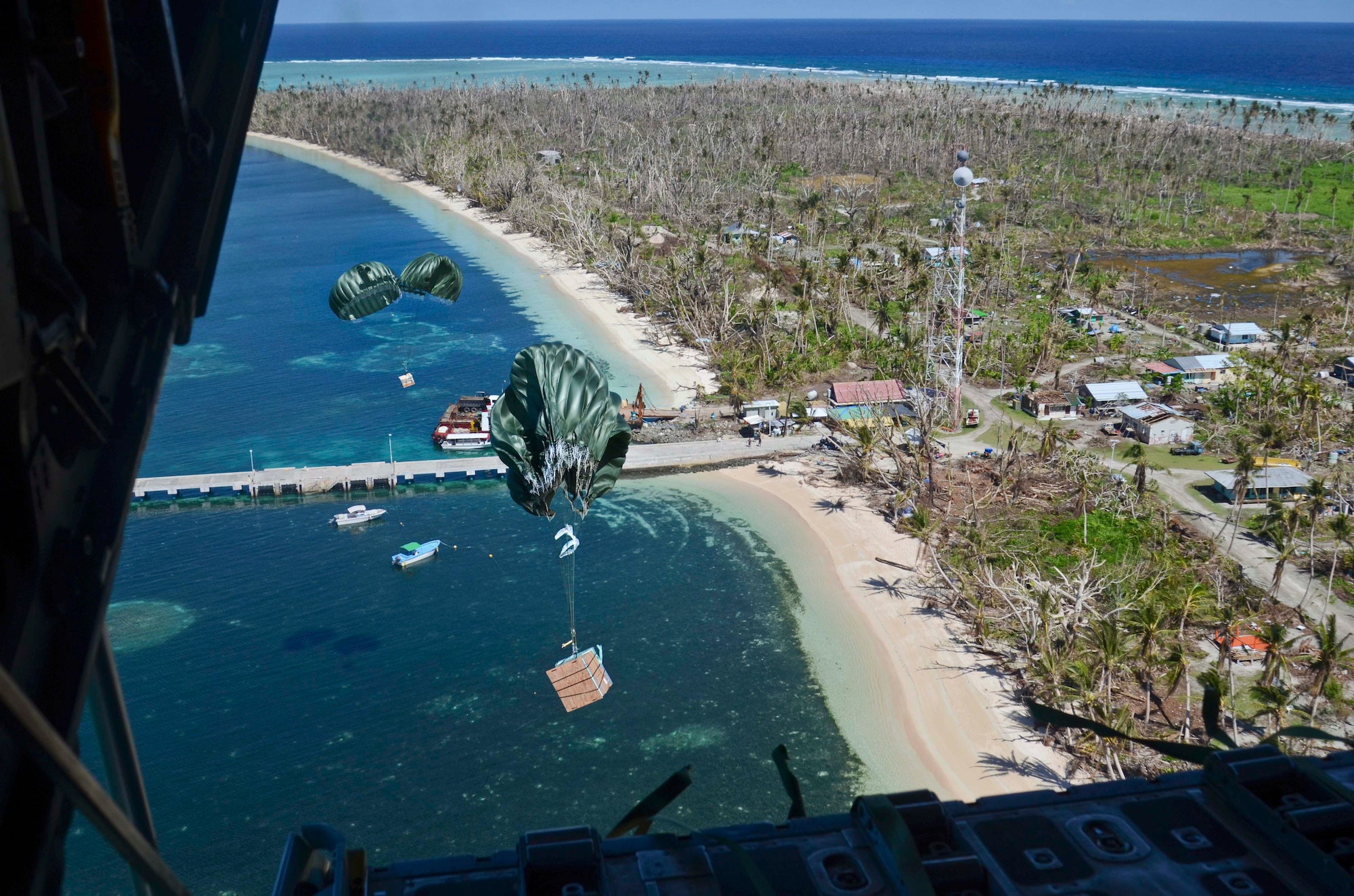 Packages make their way to the shore of Kayangel Island during an Operation Christmas Drop mission over the Pacific Ocean Dec. 11, 2013. The Island of Kayangel also experienced the devastating effects of Typhoon Haiyan that ravaged the Philippines and other island in the area. (U.S. Air Force photo by Senior Airman Marianique Santos/Released)