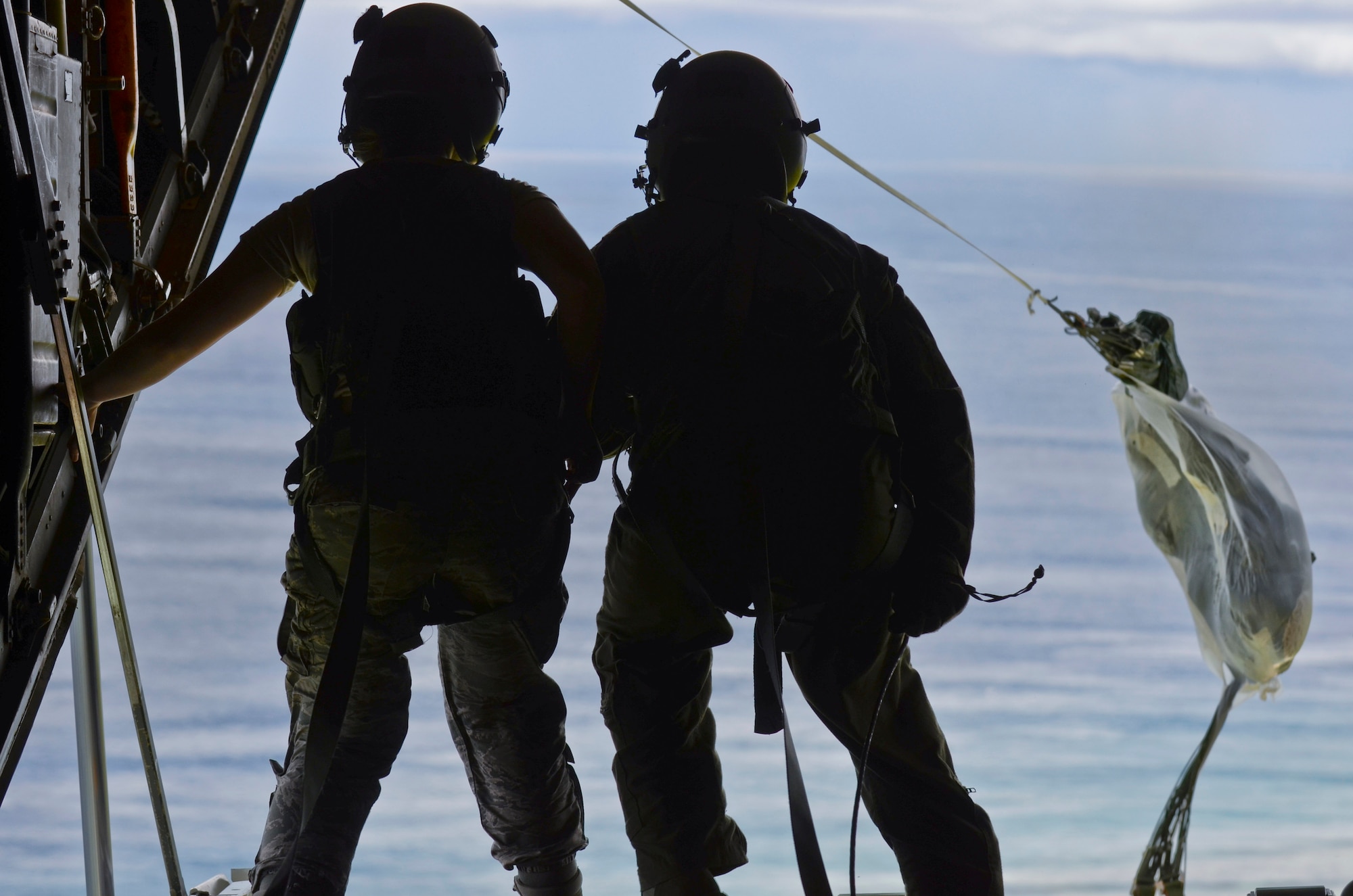 Airmen from 36th Wing push the final package off the ramp of a C-130 Hercules Dec. 11, 2013, during an Operation Christmas Drop mission over the Pacific Ocean. Every December, C-130 Hercules aircrews from the 374th Airlift Wing at Yokota Air Base, Japan, partner with the 36th Wing at Andersen AFB to airlift food, supplies and toys to islanders throughout Micronesia. (U.S. Air Force photo by Senior Airman Marianique Santos/Released)
