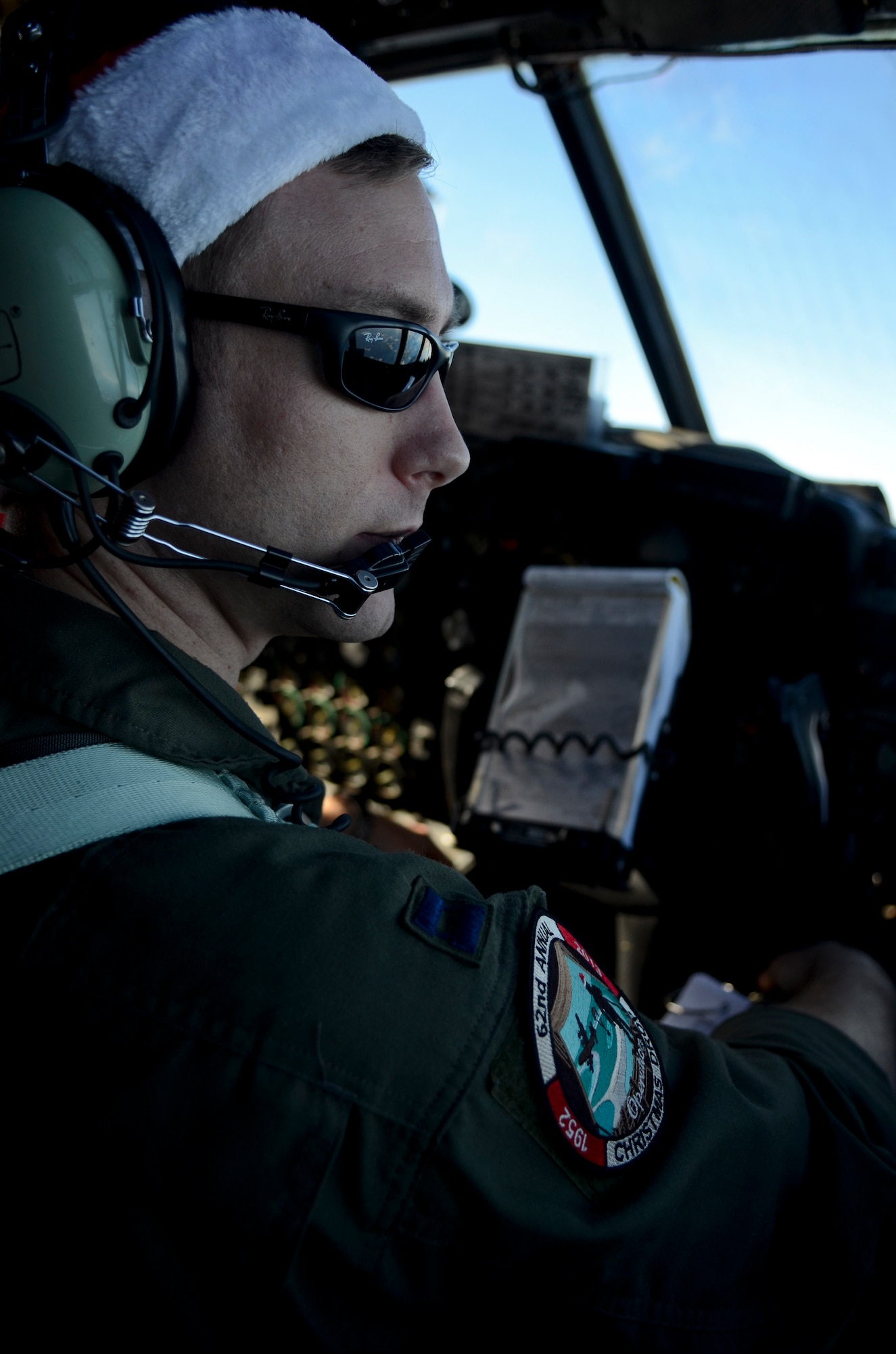 Capt. Michael Kelly, 36th Airlift Squadron C-130 Hercules pilot from Yokota Air Base, Japan, looks out the window from the flight deck of the aircraft while flying over the Pacific Ocean during an Operation Christmas Drop mission Dec. 11, 2013. This year marks the 62nd year of Operation Christmas Drop, which began in 1952, making it the world's longest running airdrop mission. (U.S. Air Force photo by Senior Airman Marianique Santos/Released)