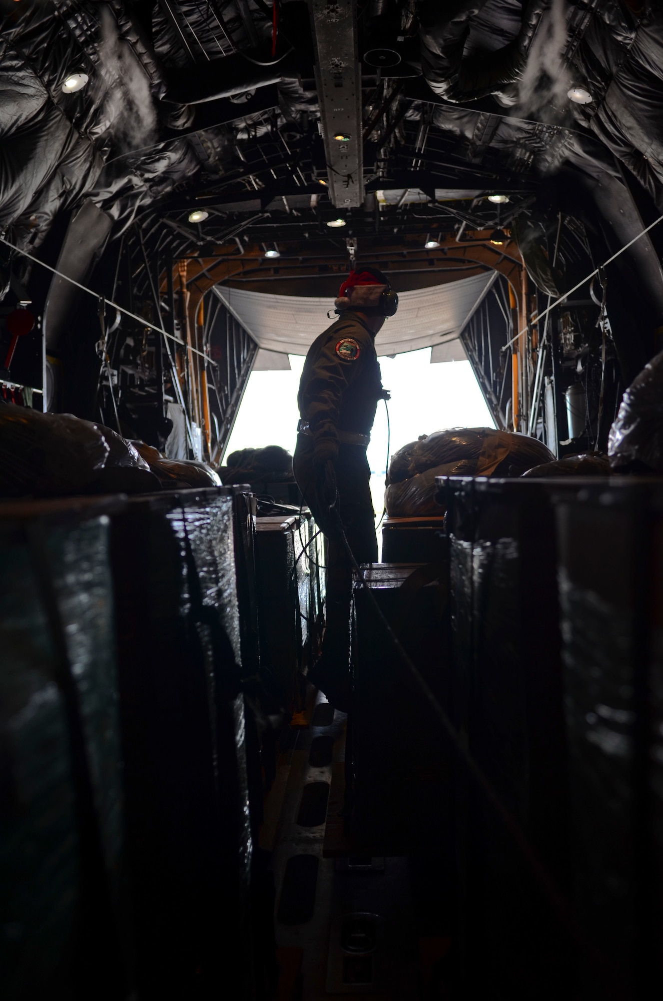 Airman 1st Class Nicholas Brown, 36th Airlift Squadron loadmaster from Yokota Air Base, Japan, makes his way to the back of a C-130 Hercules to shut the rapid doors on Andersen Air Force Base, Guam, before an Operation Christmas Drop mission Dec. 11, 2013. This year marks the 62nd year of Operation Christmas Drop, which began in 1952, making it the world's longest running airdrop mission. (U.S. Air Force photo by Senior Airman Marianique Santos/Released)