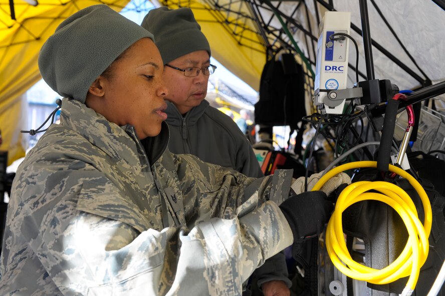 U.S. Air Force Staff Sgt. Nagelia Sheldon, left, and Maj. Alan Delacruz, 116th Medical Group, Georgia Air National Guard, set up equipment in a critical care tent during the Region 4 Homeland Response Force (HRF) external evaluation at Pelham Range, Anniston, Ala., Dec. 11, 2013. The medical group from the 116th Air Control Wing, stationed at Robins Air Force Base, Ga., is a key component of the Region 4 HRF whose mission is to respond during disasters in the Southeast U.S. region. During the evaluation, the task force comprised of Air and Army National Guardsmen, responded to various scenarios that tested their ability to save lives and mitigate suffering in order to ensure their preparedness in the event of an incident or catastrophic event. (U.S. Air National Guard photo by Master Sgt. Roger Parsons/Released)