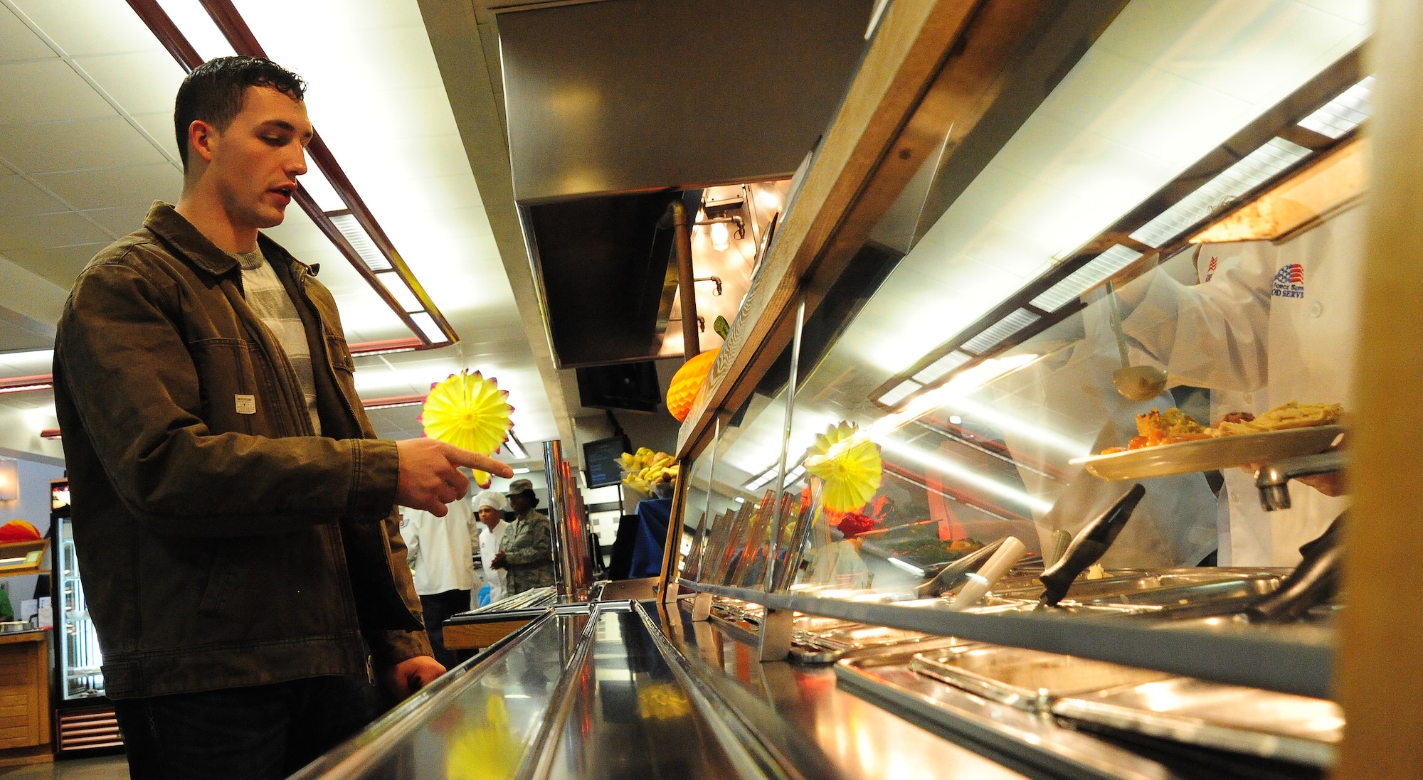 U.S. Air Force Airman 1st Class Daniel Smith, 509th Security Forces Squadron response force member, selects food items to be placed on his plate during a Thanksgiving luncheon at the Ozark Inn on Whiteman Air Force Base, Mo., Nov. 28, 2013. The dining facility served a special Thanksgiving Day meal to increase morale among Airmen and families on base. (U.S. Air Force photo by Staff Sgt. Nick Wilson/Released)