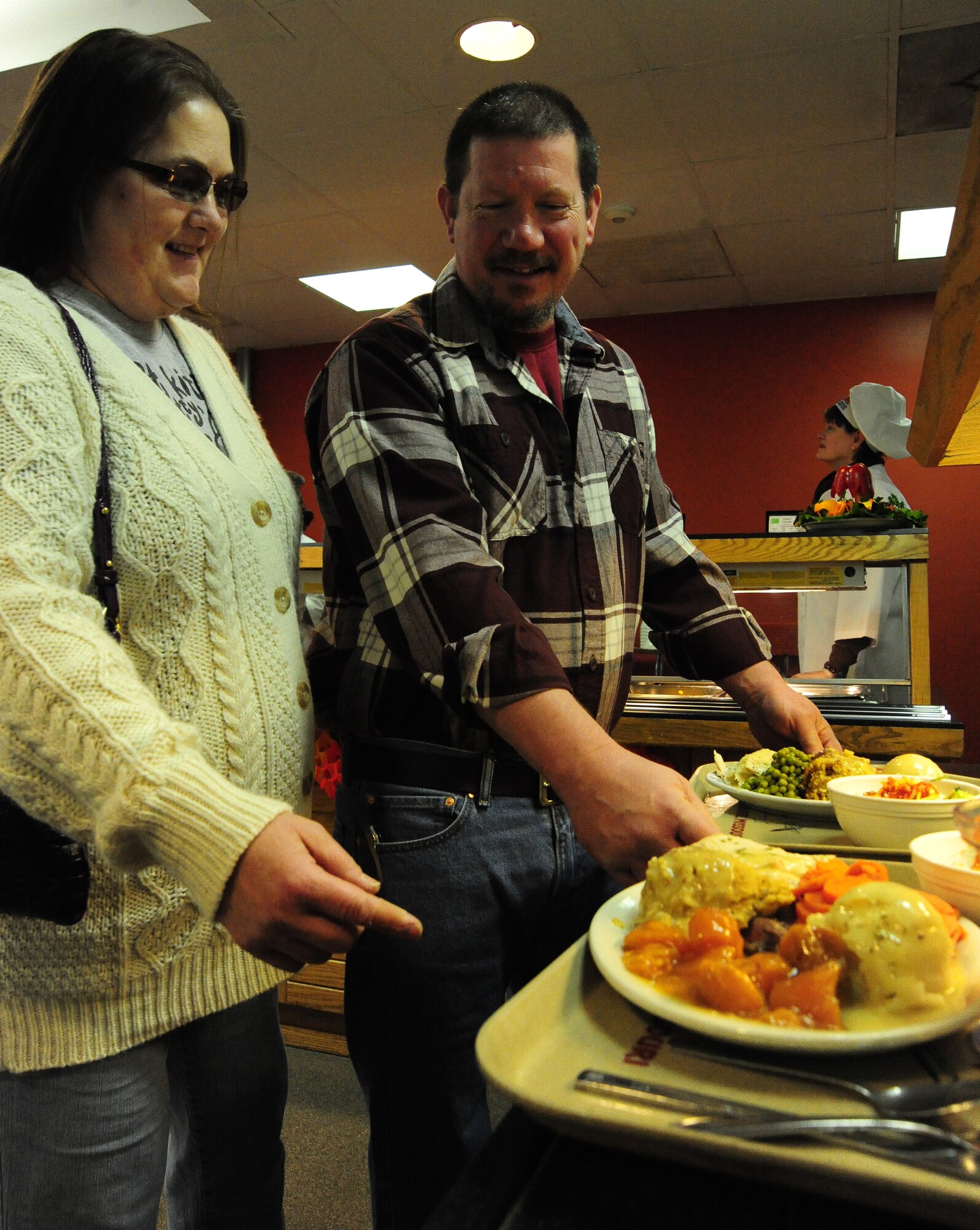 Mary McElwaine shares a laugh with her husband Steve, a retired U.S. Air Force Master Sgt., during a Thanksgiving luncheon at the Ozark Inn on Whiteman Air Force Base, Mo., Nov. 28, 2013. The dining facility staff provided a home-cooked meal to Airmen and their families and members of wing leadership volunteered to serve the meals. (U.S. Air Force photo by Staff Sgt. Nick Wilson/Released)