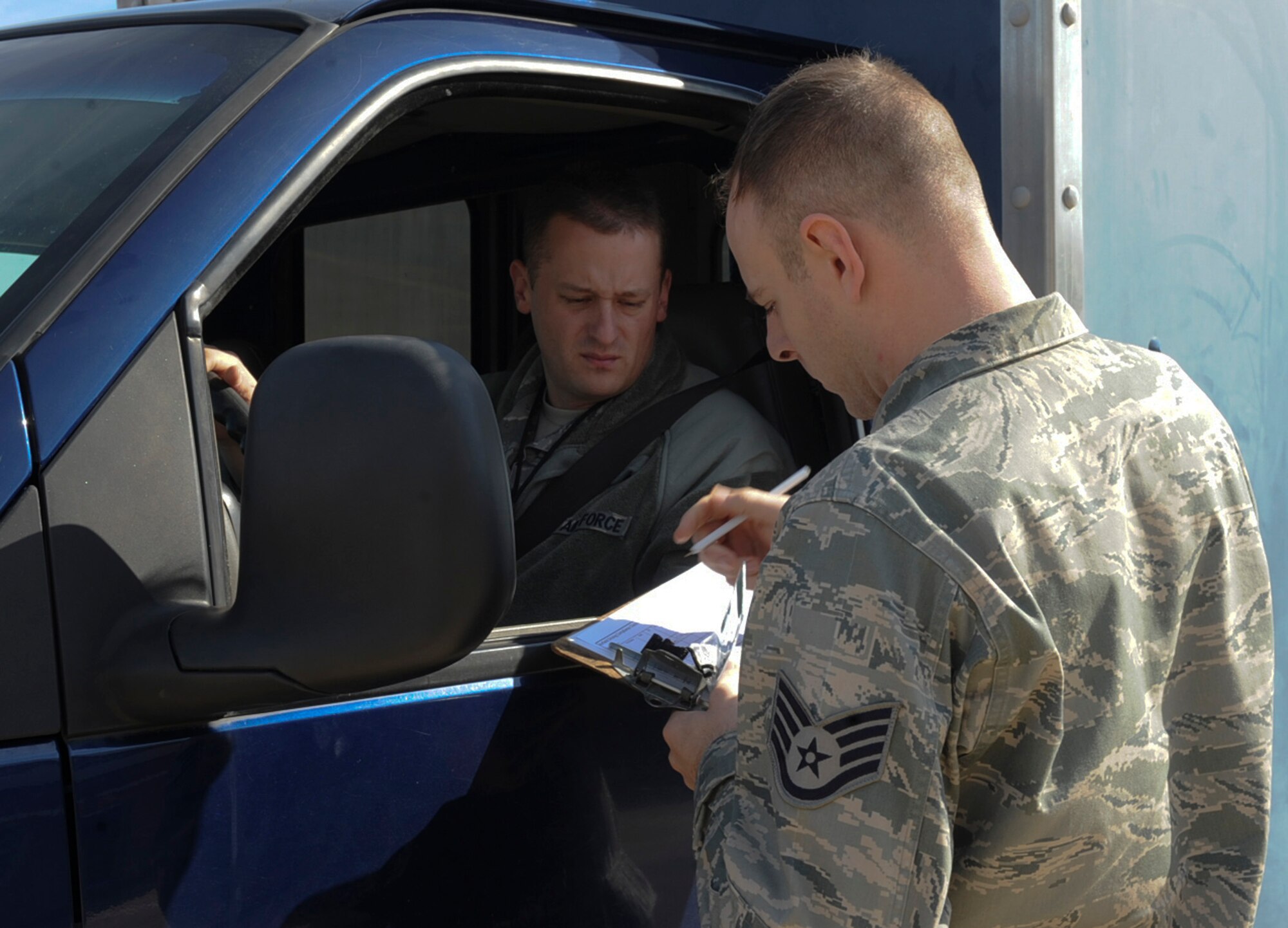 Staff Sgt. Stephen Lasher, 2nd Operations Support Squadron airfield management, conducts a random identification check on Tech. Sgt. Andrew Nawrocki, 2nd Aircraft Maintenance Squadron shift supervisor, on Barksdale Air Force Base, La., Dec. 11, 2013. Lasher regularly checks all personnel driving on the flight line to make sure they are certified to drive on the flight line and runway. (U.S. Air Force photo/Senior Airman Kristin High)