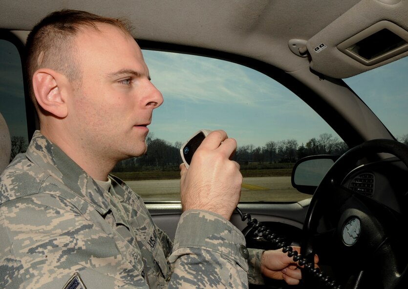 Staff Sgt. Stephen Lasher, 2nd Operations Support Squadron airfield management, communicates with the air traffic control tower to gain permission before driving onto the runway on Barksdale Air Force Base, La., Dec. 11, 2013. Airfield management Airmen search the flight line and runway daily for spalling, foreign object debris and other damage that may have occurred over time. Spalling is when a part of the runway breaks and creates holes or gaps, spreading debris across the runway. (U.S. Air Force photo/Senior Airman Kristin High)