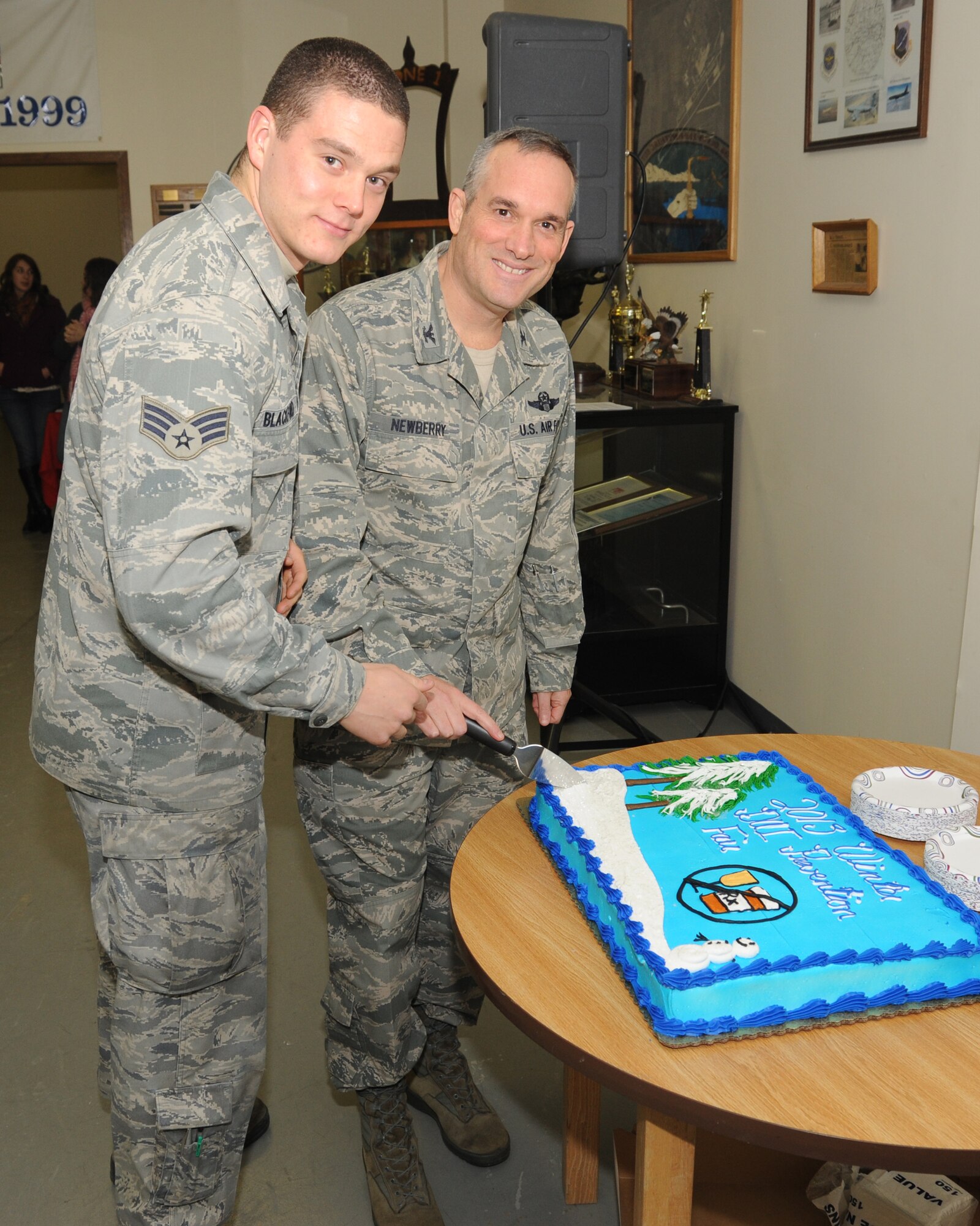 Col. Brian Newberry, 92nd Air Refueling Wing commander, cuts the cake with Senior Airman Michael Blackford, the Airman Against Drunk Driving president, during the Driving Under the Influence fair Dec. 6, 2013, at Fairchild Air Force Base, Wash. The DUI fair is an annual event held to educate people on the effects of drinking and driving. (U.S. Air Force photo by Sam Fogelman/Released)