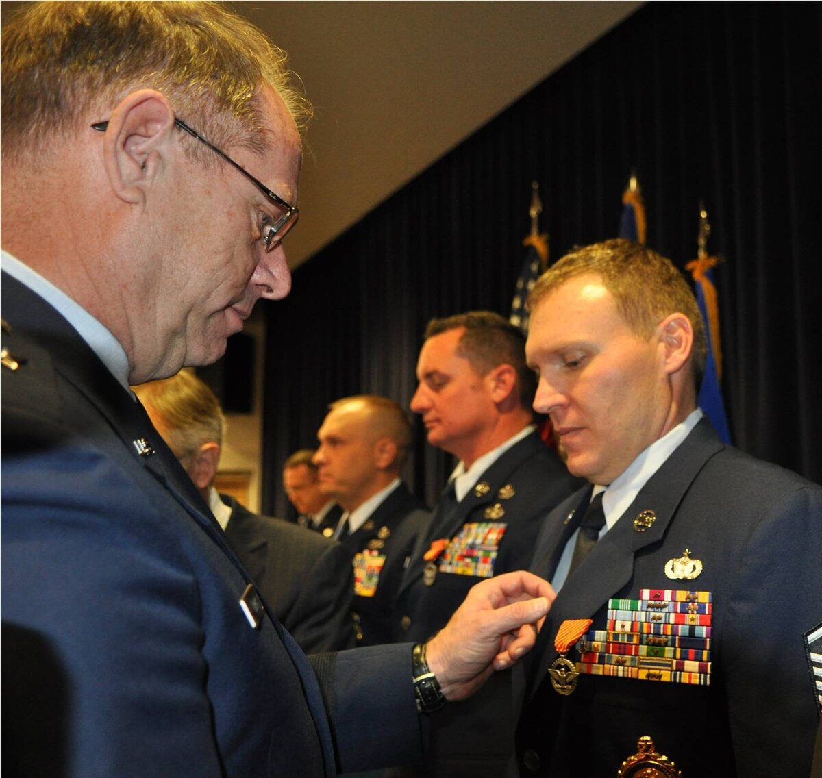 Master Sgt. Clinton Dudley, right, receives the Air Force Combat Action Medal from Nevada Adjutant General Brig. Gen. William Burks on Dec. 5 in Reno, Dudley and seven other Airmen received their medals more than a decade after participating in a battle in Afghanistan in February 2002.  NV ANG photo by Senior Airman Ashif Halim RELEASED.