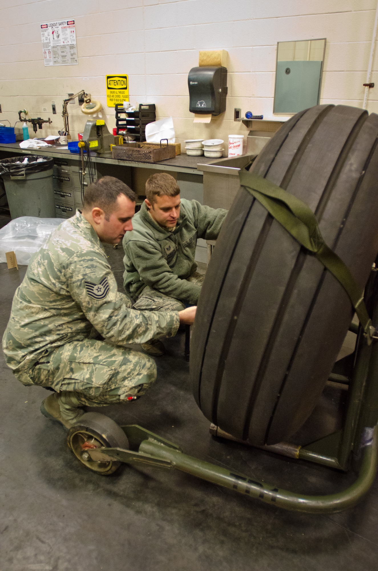 Tech. Sgt. Mike Johnson (right), a crew chief from the Kentucky Air National Guard's 123rd Aircraft Maintenance Squadron, speaks to Staff Sgt. Brian Hinckley, a crew chief from the Connecticut Air National Guard's 103rd Aircraft Maintenance Squadron, about the tires of the C-130 Hercules aircraft at the Kentucky Air National Guard base in Louisville, Ky., on Nov. 14, 2013.  The Connecticut unit is converting from C-21A Learjets to the Hercules transport. (U.S. Air National Guard photo by Master Sgt. Phil Speck)