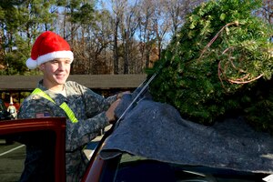 U.S. Army Pvt. Nicholas Steele, 1st Battalion, 222nd Aviation Regiment Advanced Individual Training student, secures a Christmas tree to a dependent’s vehicle during the annual “Trees for Troops” event at Fort Eustis, Va., Dec. 11, 2013. Approximately 20 AIT soldiers volunteered to help carry and load trees for Service members and their families. (U.S. Air Force photo by Staff Sgt. Ashley Hawkins/Released)
