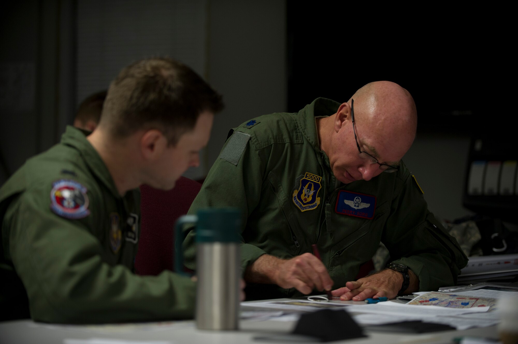 U.S. Air Force Lt. Col. Perry Sorg (right) and 1st Lt. Eric Foley of the 910th Airlift Wing, Youngstown Air Reserve Station, Ohio plan an airlift mission during the Randy Oler Memorial Operation Toy Drop on Fort Bragg, N.C. 2013 marks the 16th year for the Randy Oler Memorial Operation Toy Drop which collects toy donations for children and families in need and gives paratroopers the opportunity to jump with foreign jumpmasters. Soldiers donate a new toy in exchange to jump with a foreign jumpmaster and earn foreign jump wings. The 16th Annual Randy Oler Operation Toy Drop, hosted by the U.S. Army Civil Affairs and Psychological Command (Airborne), is the largest combined airborne operation in the world where Fort Bragg's paratroopers and allied jumpmasters donate toys to be distributed to children's homes and social services agencies across the local community. (U.S. Air Force Photo by Master Sgt. Adrian Cadiz, 1st Combat Camera Squadron)