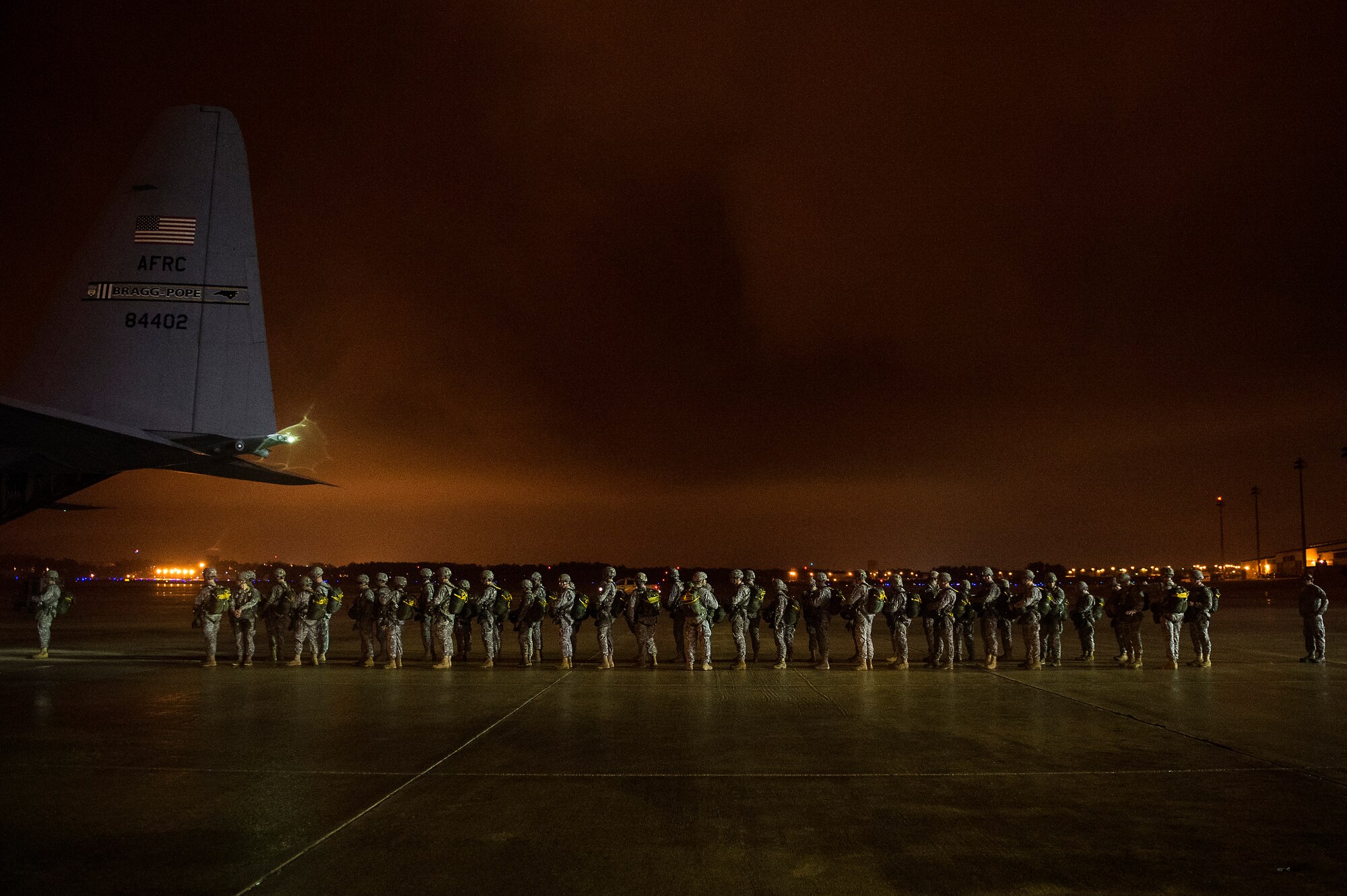 U.S. Army Soldiers from the 82nd Airborne Division line up to board a C-130 Hercules during Operation Toy Drop on Fort Bragg, N.C., Dec. 7, 2013.  The 16th Annual Randy Oler Operation Toy Drop, hosted by the U.S. Army Civil Affairs & Psychological Operations Command (Airborne), is the largest combined airborne operation in the world where Fort Bragg's paratroopers and allied jumpmasters donate toys to be distributed to children's homes and social service agencies across the local community.  (U.S. Air Force photo by Senior Airman James Richardson, 1st Combat Camera Squadron)
