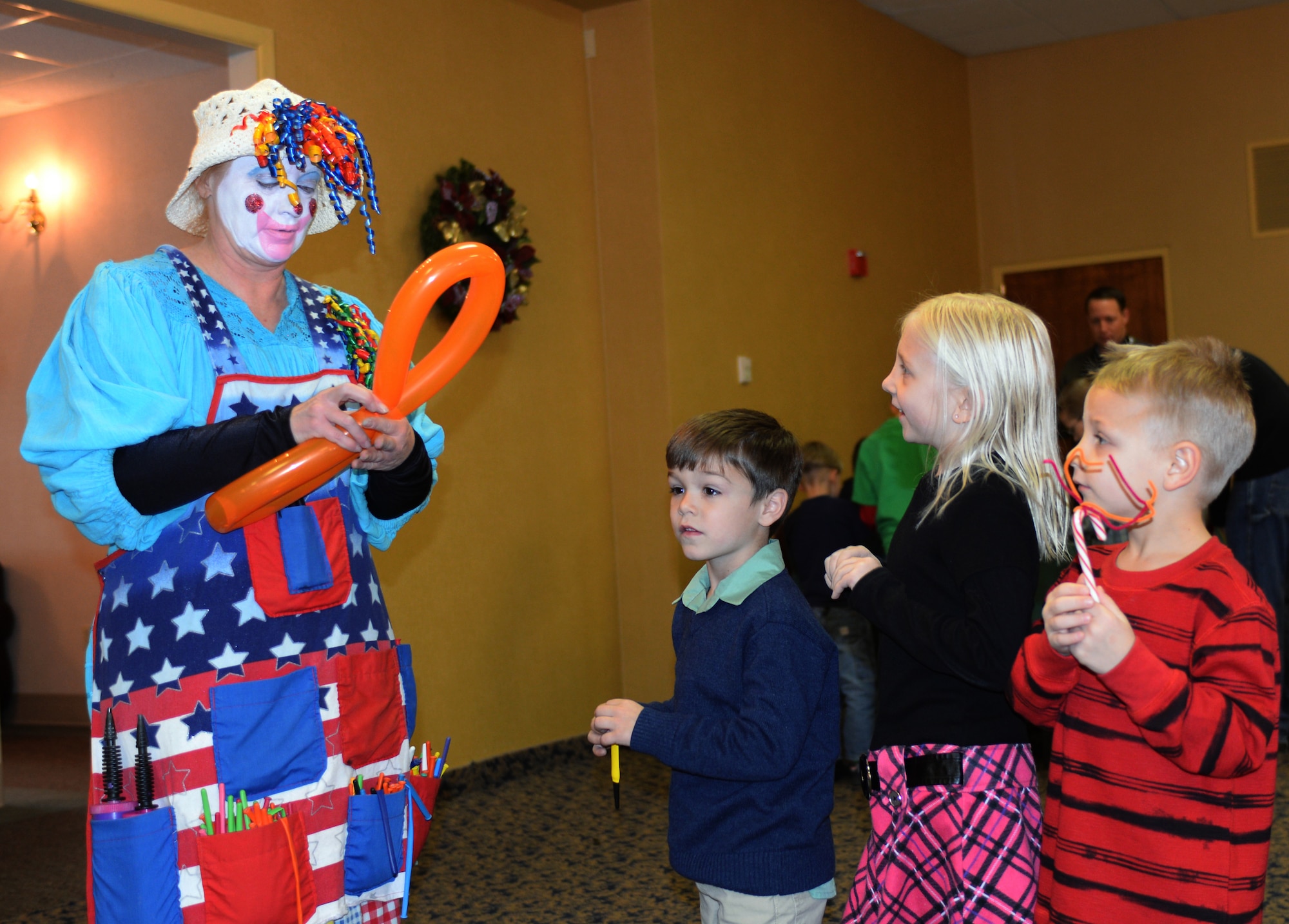 Holly Kennedy from the Central States Fair Office in Rapid City, S.D., makes balloon animals for children during the Breakfast with Santa event in the Dakota’s Club at Ellsworth Air Force Base, S.D., Dec. 7, 2013. The breakfast invited Airmen and their families to eat with Santa while enjoying entertainment such as arts and crafts, face painting, holiday goodies and had the opportunity to have a picture taken with Santa Claus. (U.S. Air Force photo by Senior Airman Zachary Hada/Released)