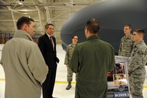 (From left) Col. Christopher Mann, 319th Air Base Wing vice commander, and North Dakota Lt. Gov. Drew Wrigley, listen to a briefing regarding the RQ-Block 40 Global Hawk from members of the 69th Maintenance Squadron, Dec. 10, 2013, on Grand Forks Air Force Base, N.D. Wrigley visited the base to get a first-hand view of the mission and see how unmanned aerial vehicles operate. (U.S. Air Force photo/Airman 1st Class Zachiah Roberson)