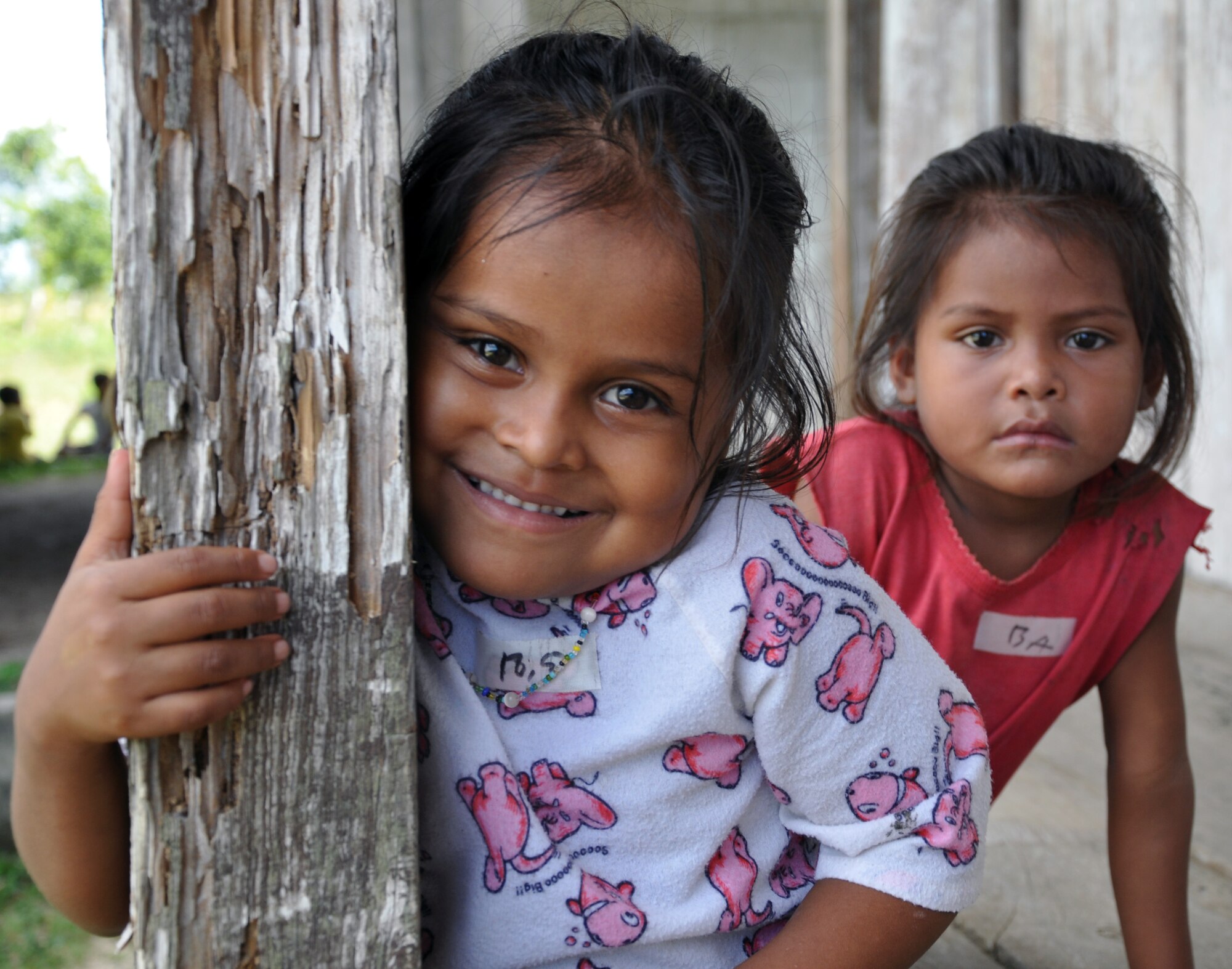 Two small Honduran girls wait to receive medical treatment during a Medical Readiness Training Exercise (MEDRETE) conducted by Joint Task Force-Bravo in the Department of Gracias a Dios, Honduras, Dec. 4, 2013.  Joint Task Force-Bravo routinely partners with the Honduran Ministry of Health and the Honduran military to perform these humanitarian aid missions to provide medical care to the most isolated regions of the country. (U.S. Air Force photo by Capt. Zach Anderson)