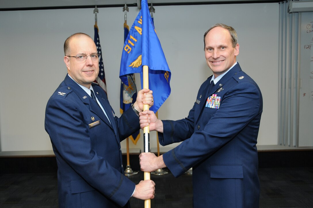Lt. Col. David Tarter, 911th Operation Support Squadron incoming commander, receives the guidon from, Col. Joseph M. Potts, 911th Operations Group commander, during an assumption of command ceremony at the Pittsburgh International Airport Air Reserve Station, Dec. 8, 2013. (U.S. Air Force photo by Senior Airman Joshua J. Seybert)