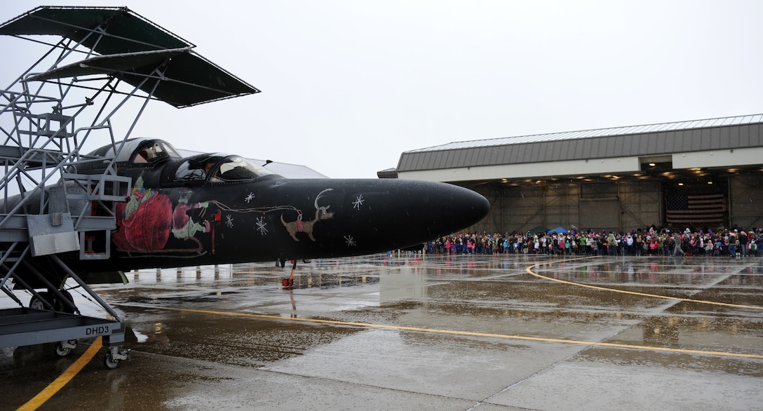 More than 500 families wait for Santa Claus to disembark a U-2 Dragon Lady during the annual Children’s Holiday Party Dec. 7, 2013. Beale Airmen painted special holiday nose art on the U-2 to celebrate the event. (U.S. Air Force photo by Staff Sgt. Robert M. Trujillo/Released)