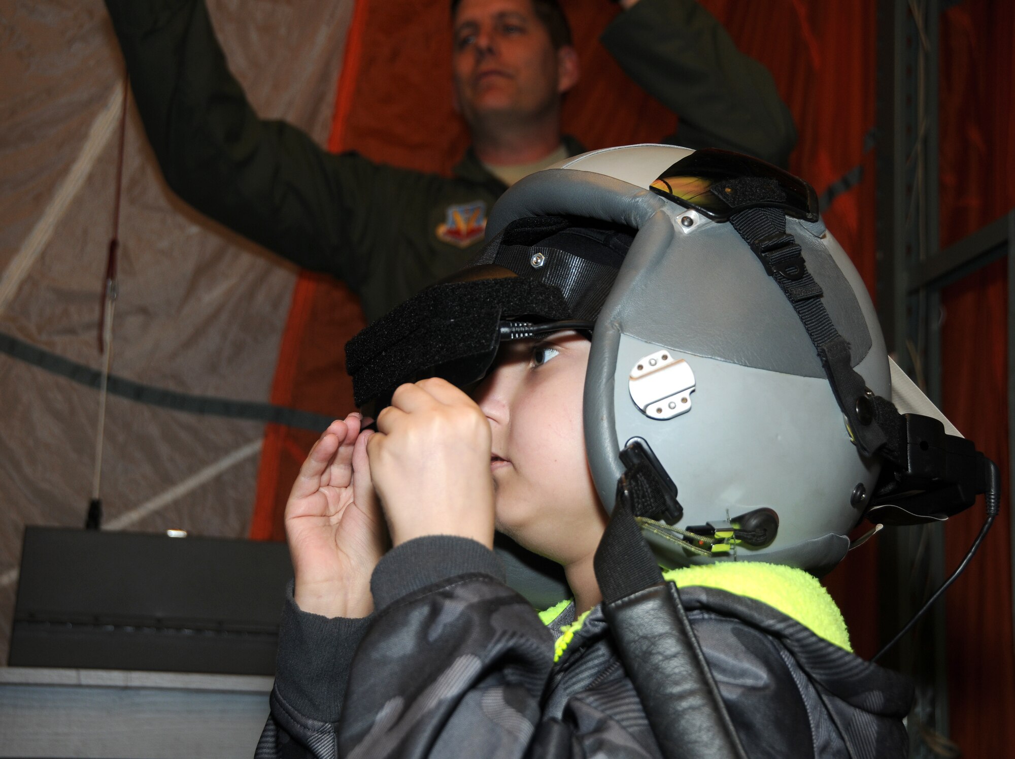 Pilot for a day Skyler Leroy takes flight on the 188th Operations Group's parachute simulator while Lt. Col. Toby Brallier steers the rigging.  (U.S. Air National Guard photo by Senior Airman John Hillier/188th Fighter Wing Public Affairs)