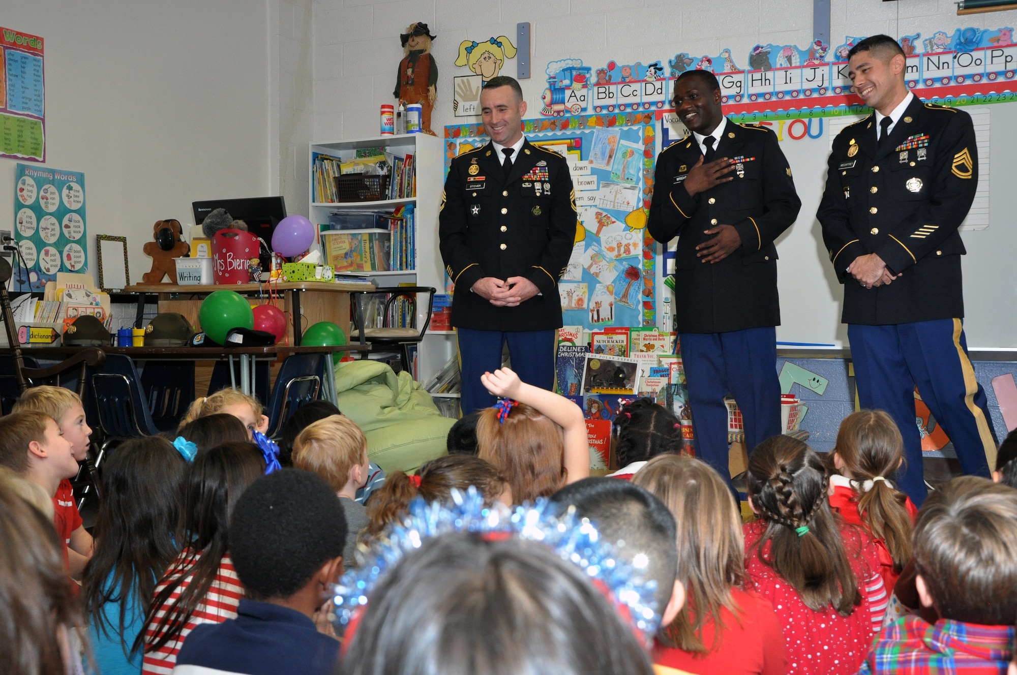 From left, Sgt. 1st Class David Stover II, Spc. Frankie Wright and Sgt. 1st Class Ryan
McCaffrey explain to first and third graders how uniform ribbons and
insignia are earned during a "Salute to Veterans" tribute at Grafton Bethel
Elementary School, located in Yorktown, Va., Dec. 6, 2013. The Soldiers
performed as the color guard during an assembly in the school's cafeteria at
the beginning of the tribute. Following the assembly, the Soldiers discussed
how their personal military experiences included humanitarian assistance.
Stover and McCaffrey are the U.S. Army Drill Sergeants of the Year,
stationed at U.S. Army Initial Military Training, Fort Eustis, Va. Wright is
assigned to U.S. Army Training and Doctrine Command Headquarters and
Headquarters Company, Fort Eustis, Va. (U.S. Army photo by Stephanie Slater/Released)