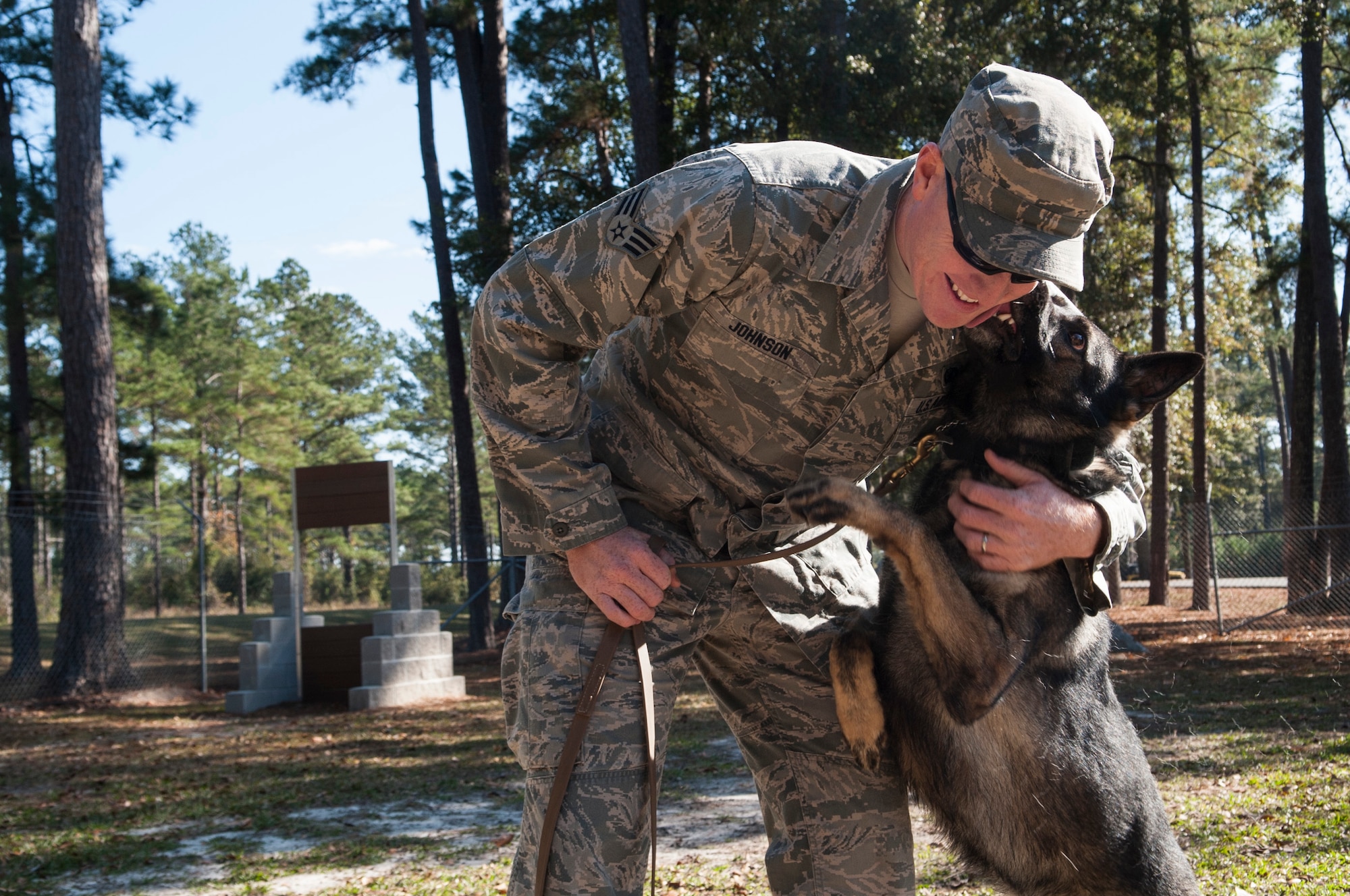 U.S. Air Force Senior Airman Brandon Johnson, 822d Base Defense Squadron K-9 handler, pets military work dog Mex at Moody Air Force Base, Ga., Dec. 2, 2013. MWDs work alongside their handlers at home stations and deployed locations. (U.S. Air Force photo by Airman 1st Class Sandra Marrero/Released) 
