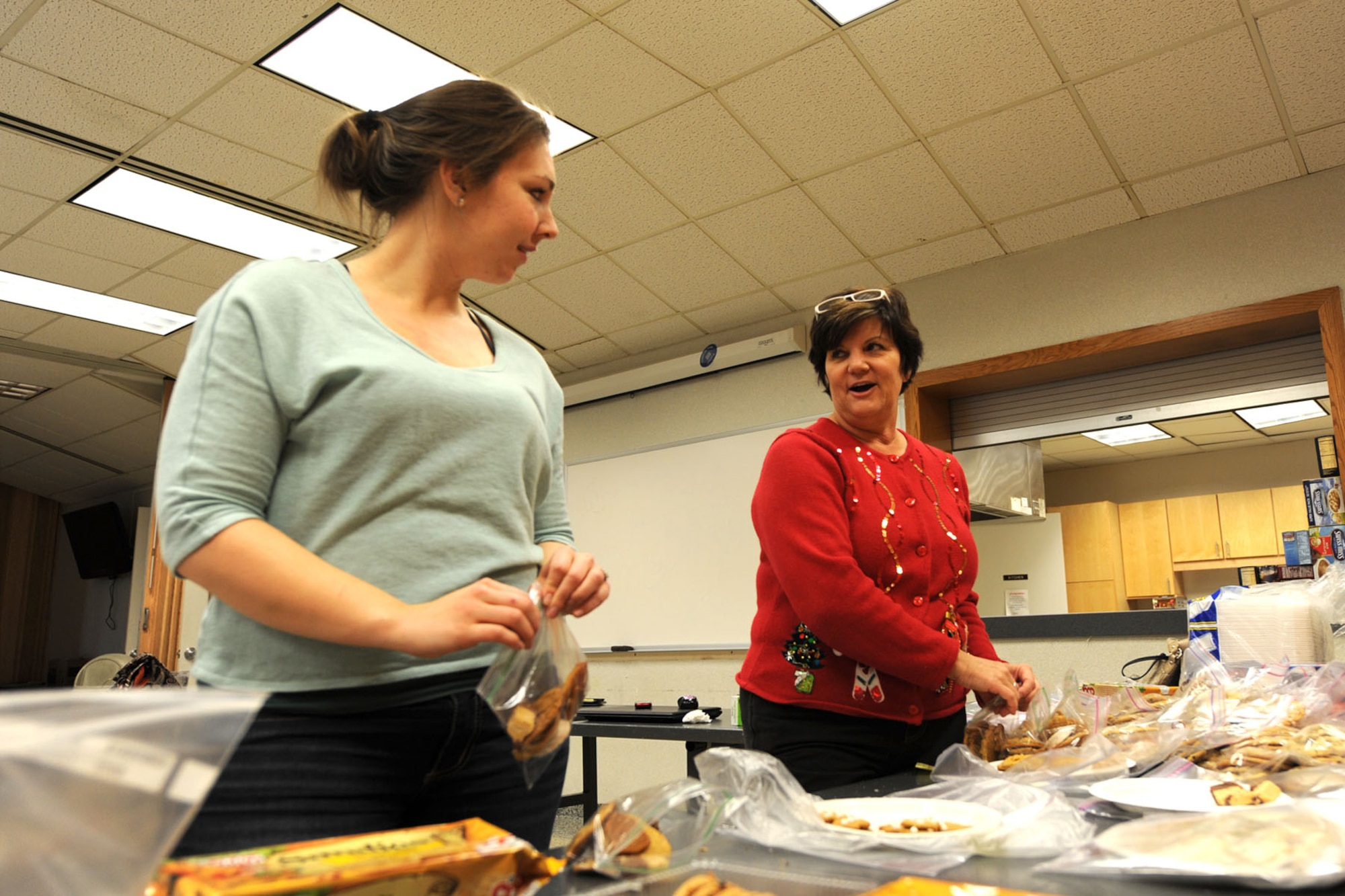 PETERSON AIR FORCE BASE, Colo. – Jenna Celmer (left), Peterson, Schriever, Cheyenne Mountain Spouses’ Club special activities coordinator, and Victoria Aquin, PSC Spouses’ Club first vice president and volunteer, package more than 6,000 homemade cookies as part of the PSC Spouses’ Club Cookies for the Troops drive Dec. 4. Celmer, Aquin and more than 20 other volunteers used the baked goods to help spread homemade, holiday cheer to the more than 400 Airmen residing in the Team Pete dorms and also to the 30 on-base squadrons running 24-hour operations. (U.S. Air Force Photo/Staff Sgt. J. Aaron Breeden)
