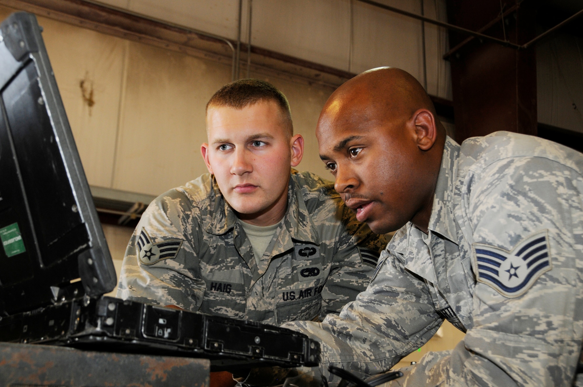 Senior Airman Michael Haig and Staff Sgt. Cornell Martin review a technical order before rewiring a generator at the 379th Air Expeditionary Wing in Southwest Asia, Dec. 9, 2013. Haig a Constableville, N.Y. native and Martin an El Paso, Texas, native, are 379th Expeditionary Maintenance Squadron Aerospace Ground Equipment specialists deployed from Dyess, Air Force Base, Texas. (U.S. Air Force photo/Senior Airman Hannah Landeros)