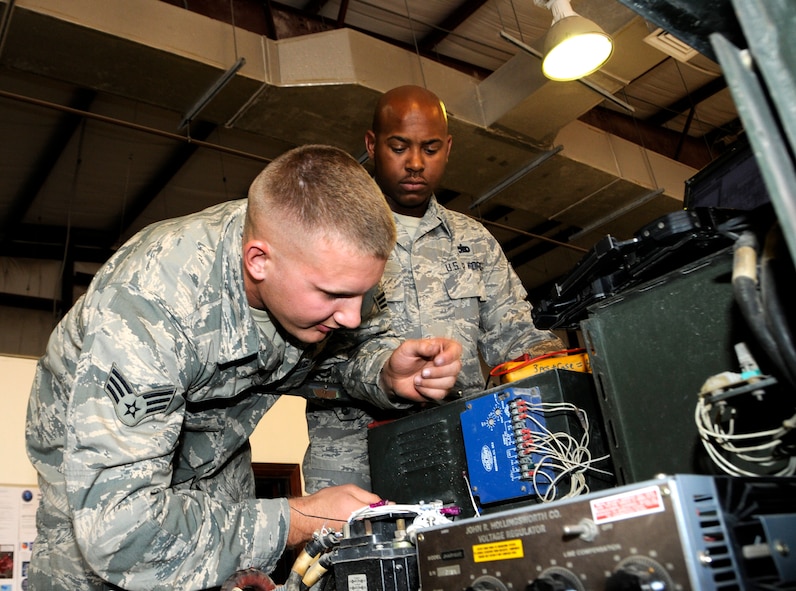 Senior Airman Michael Haig and Staff Sgt. Cornell Martin rewire a generator at the 379th Air Expeditionary Wing in Southwest Asia, Dec. 9, 2013. Haig a Constableville, N.Y. native and Martin an El Paso, Texas, native, are 379th Expeditionary Maintenance Squadron Aerospace Ground Equipment specialists deployed from Dyess, Air Force Base, Texas.  (U.S. Air Force photo/Senior Airman Hannah Landeros)