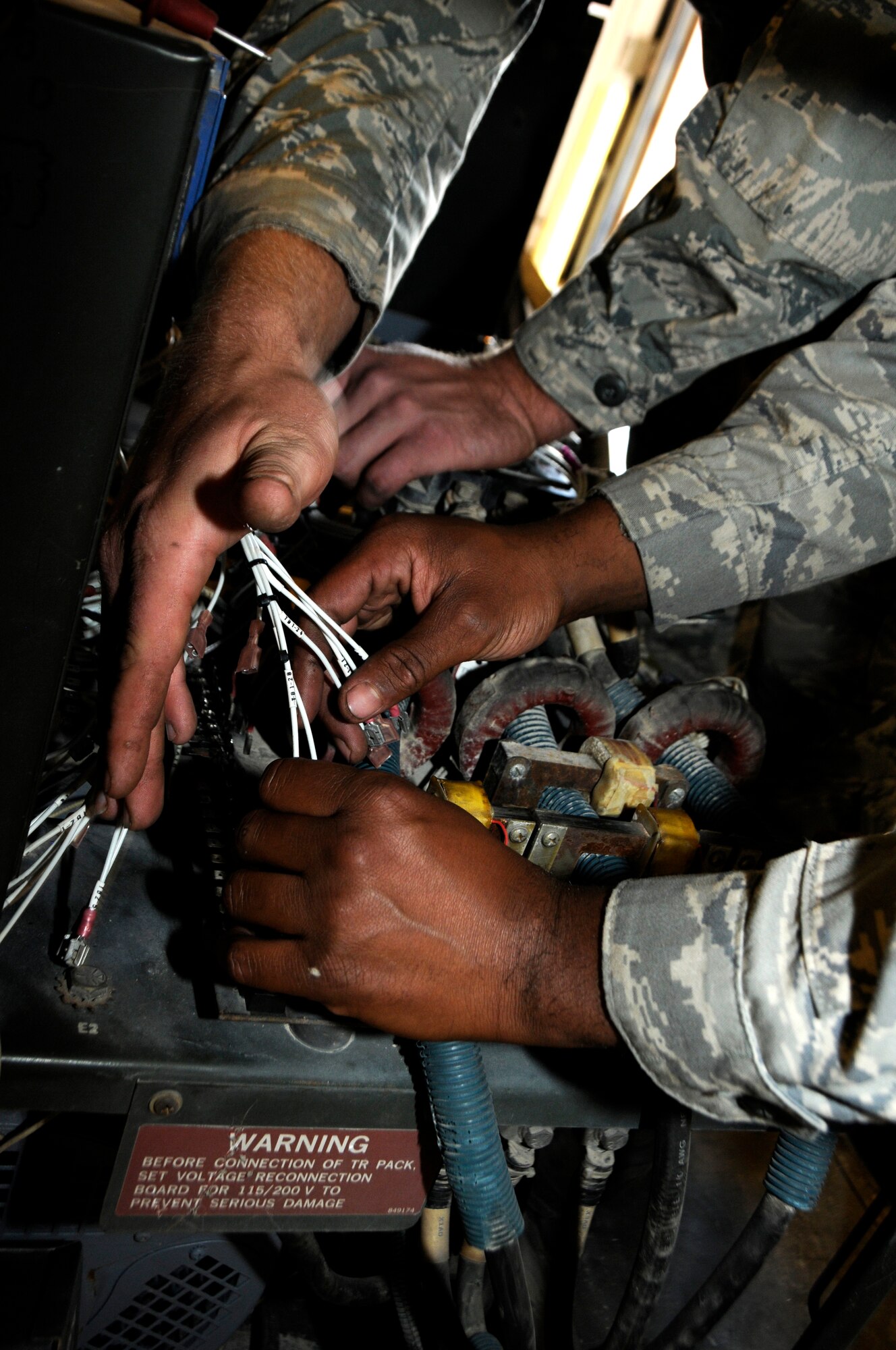 Senior Airman Michael Haig and Staff Sgt. Cornell Martin rewire a generator at the 379th Air Expeditionary Wing in Southwest Asia, Dec. 9, 2013. Haig a Constableville, N.Y. native and Martin an El Paso, Texas, native, are 379th Expeditionary Maintenance Squadron Aerospace Ground Equipment specialists deployed from Dyess, Air Force Base, Texas.  (U.S. Air Force photo/Senior Airman Hannah Landeros)