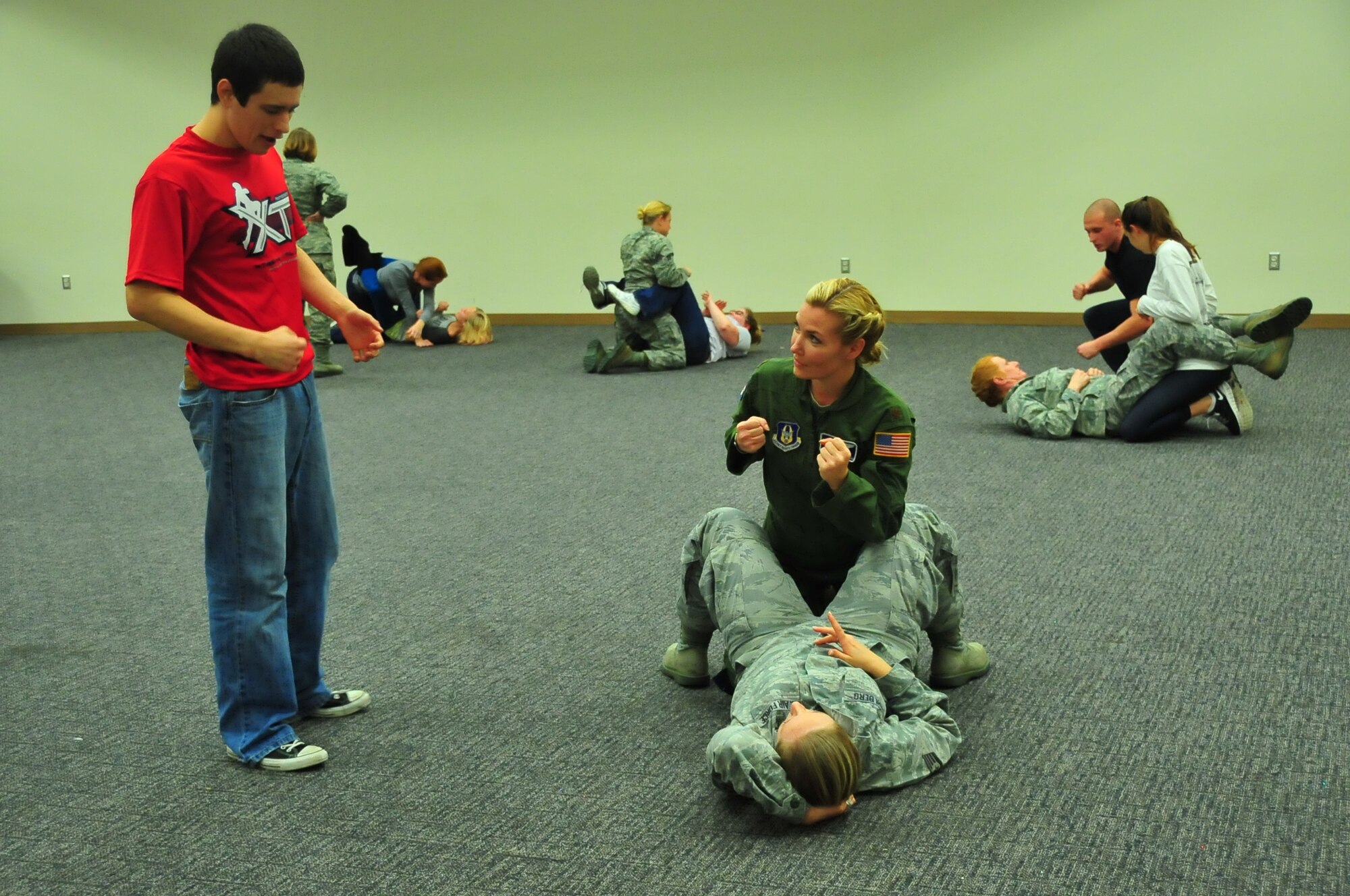 Alex Harrel, a mixed martial arts instructor and fighter, explains a grappling technique to Maj. Nicole Mitchell, 53rd Aerial Weather Reconnaissance Squadron aerial reconnaissance weather officer, and Staff Sgt. Erin Dahlberg, 403rd Aeromedical Staging Squadron medical technician. The 403rd Wing hosted a self-defense course Dec. 8, 2013, for female Airmen and reservists’ wives and daughters. (U.S. Air Force photo/Maj. Marnee A.C. Losurdo)