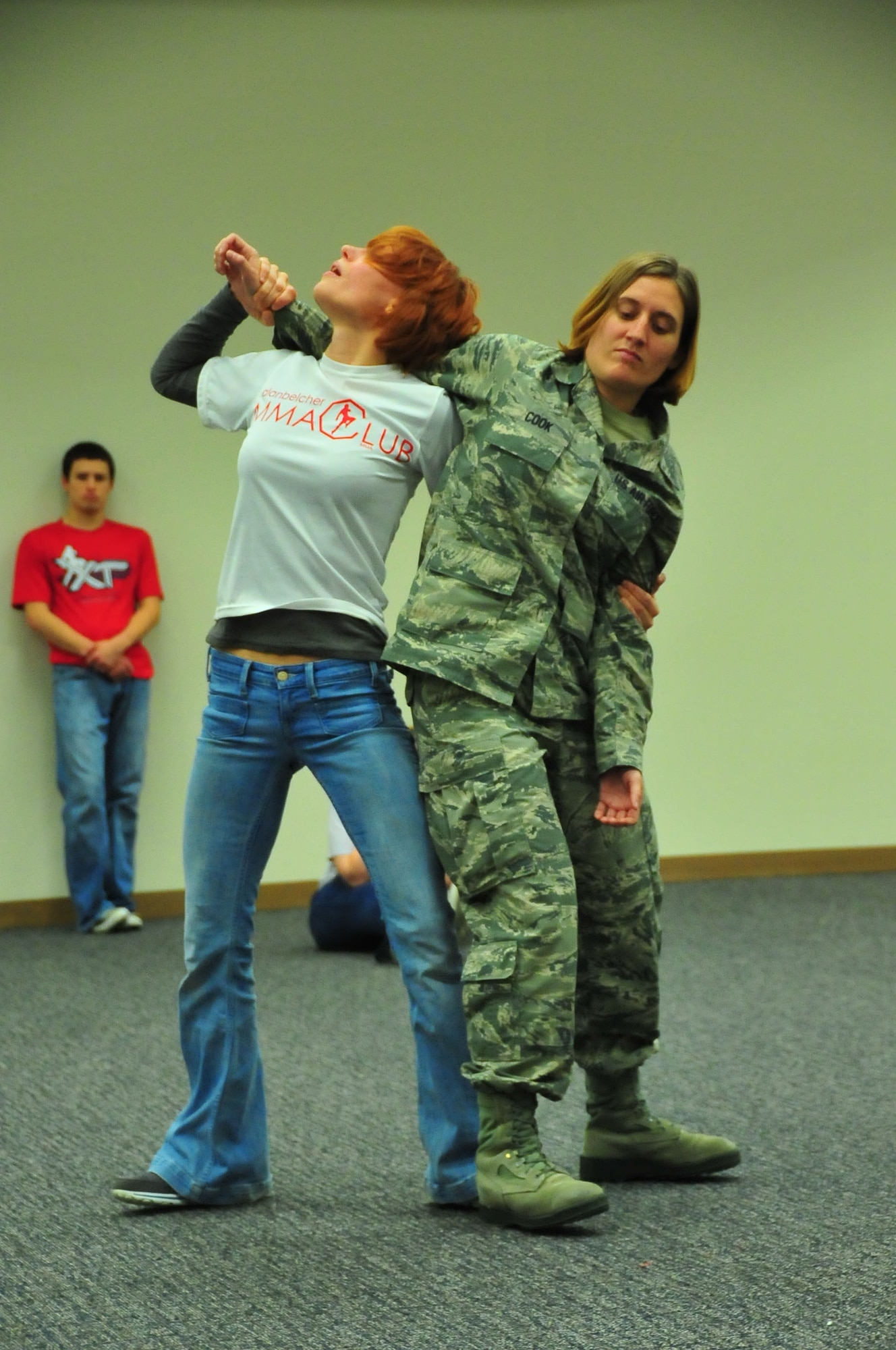 Ann E. Sanford, a Brazilian Jiu Jitsu and self-defense instructor, demonstrates an evasive maneuver with the assistance of Senior Airman Laura Cook, 335th Training Squadron, to a group of 403rd Wing Airmen and family members. Sanford spent two hours showing students Jiu Jitsu techniques, which focuses on grappling and ground fighting. (U.S. Air Force photo/Maj. Marnee A.C. Losurdo)