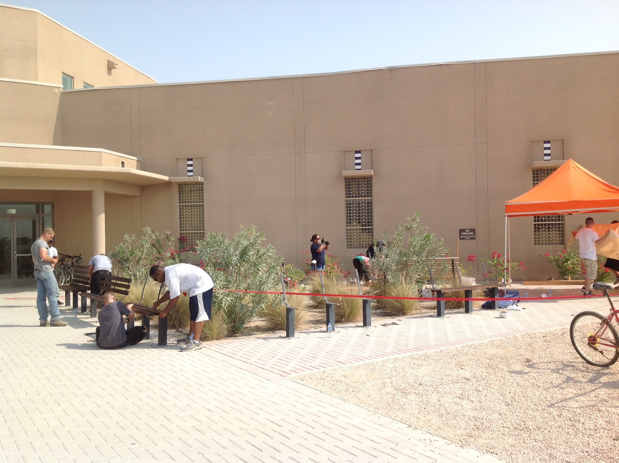 Volunteers from the First Four organization refurbish and stain worn benches outside the Blatchford-Preston Complex mall. With the support of 46 Airmen and Soldiers, 16 benches were refurbished over a three day period. The mission of the First Four is to improve morale, provide welfare, and inspire growth for all individuals assigned here. (Courtesy photo)