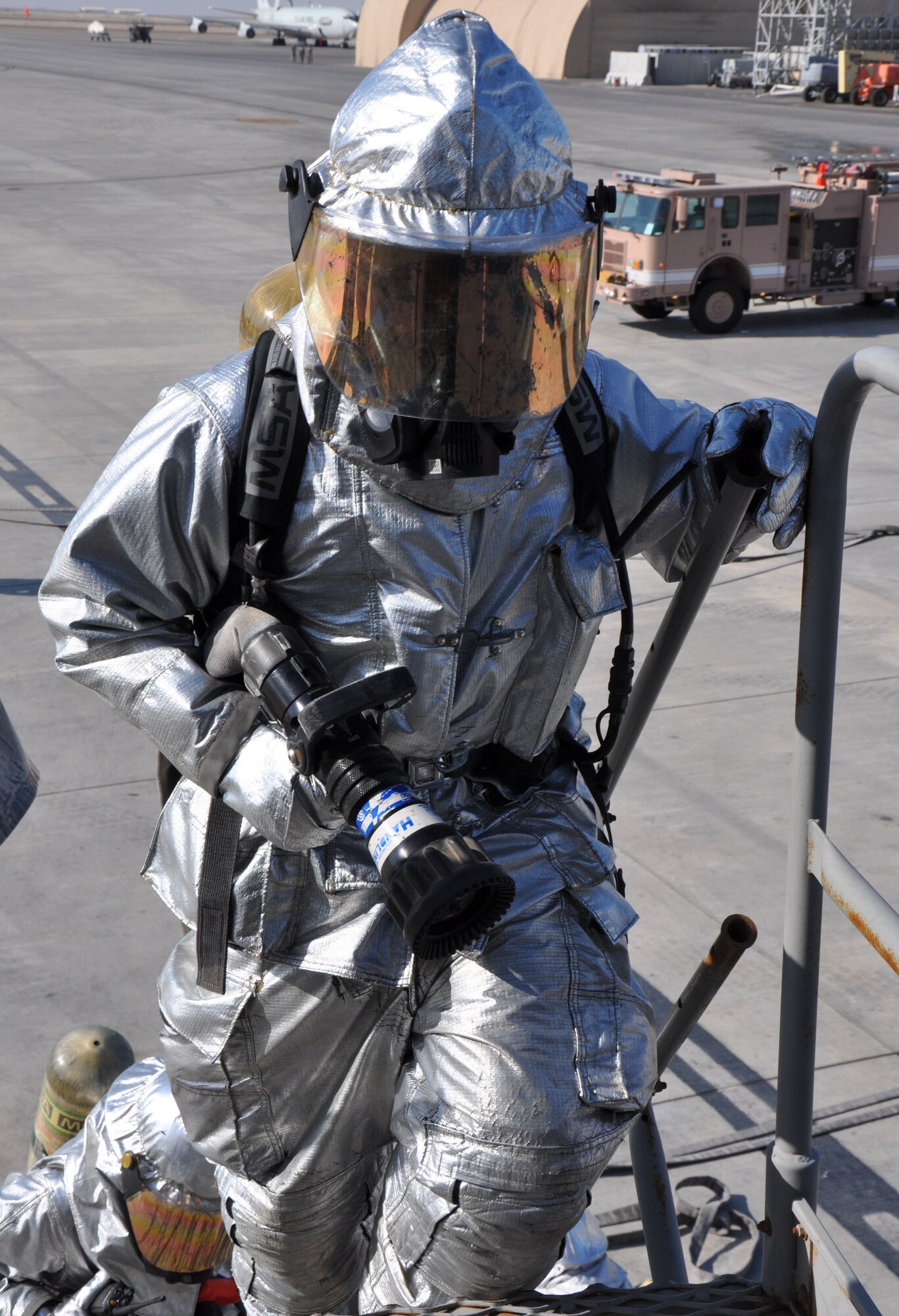 Firefighters, who are assigned to the 380th Expeditionary Civil Engineer Squadron here, prepare to board a KC-10 Extender and advance their attack line to fight simulated fire and search for victims during a training scenario Dec. 10, 2013. (U.S. Air Force photo by Master Sgt. April Lapetoda/Released) 