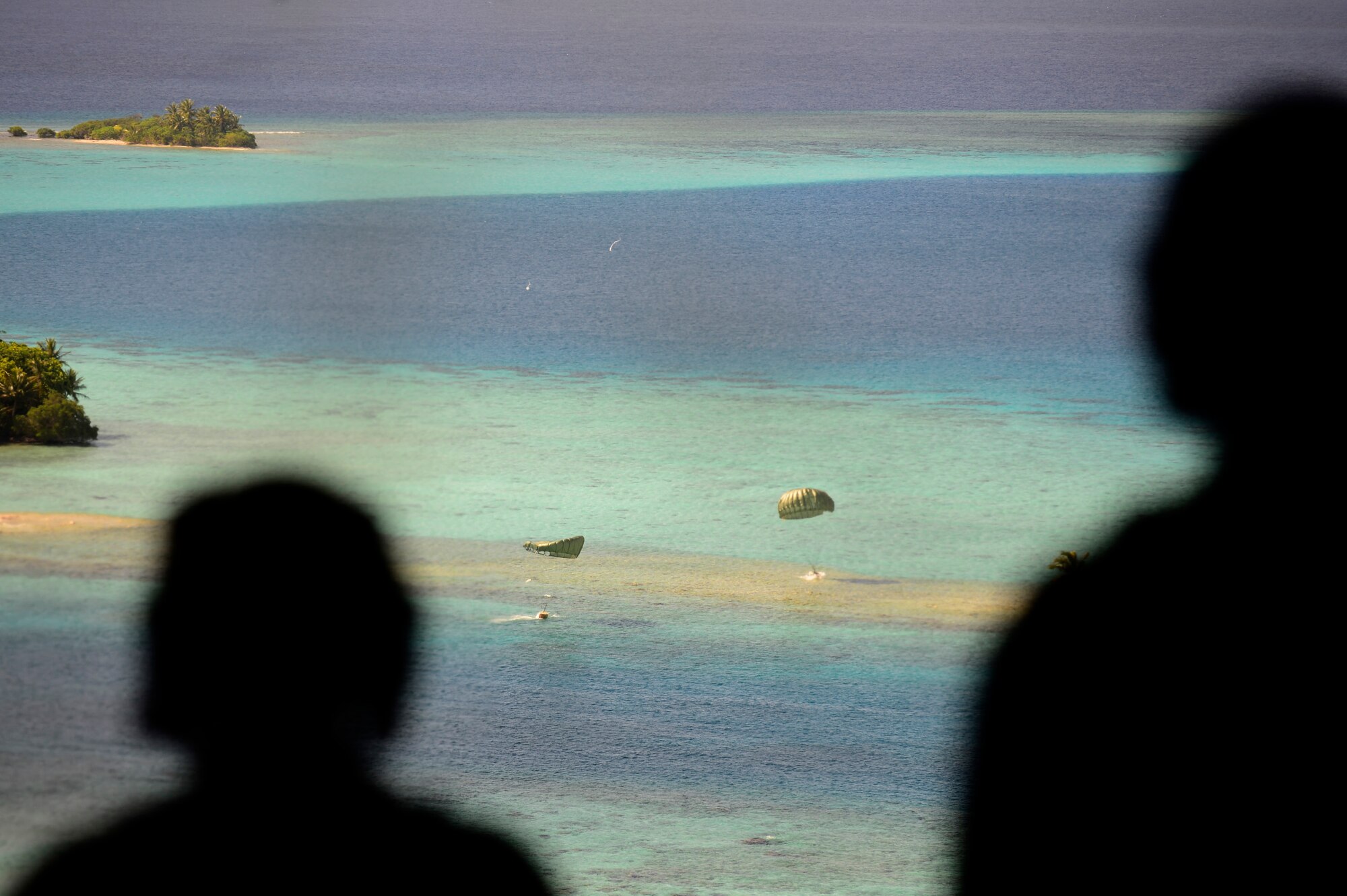 Low-cost, low-altitude airdrop bundles containing relief supplies fall from a C-130H aircraft to the island of Ifalik, Federated States of Micronesia, during Operation Christmas Drop Dec. 10, 2013. This year marks the 62nd year of Operation Christmas Drop, which began in 1952, making it the world's longest running airdrop mission. Every December, C-130 Hercules crews from the 374th Airlift Wing at Yokota Air Base, Japan, partner with the 36th Wing at Andersen Air Force Base, Guam, to airlift food, supplies and toys to islanders throughout Micronesia. (U.S. Air Force photo by 2nd Lt. Jake Bailey/Released)