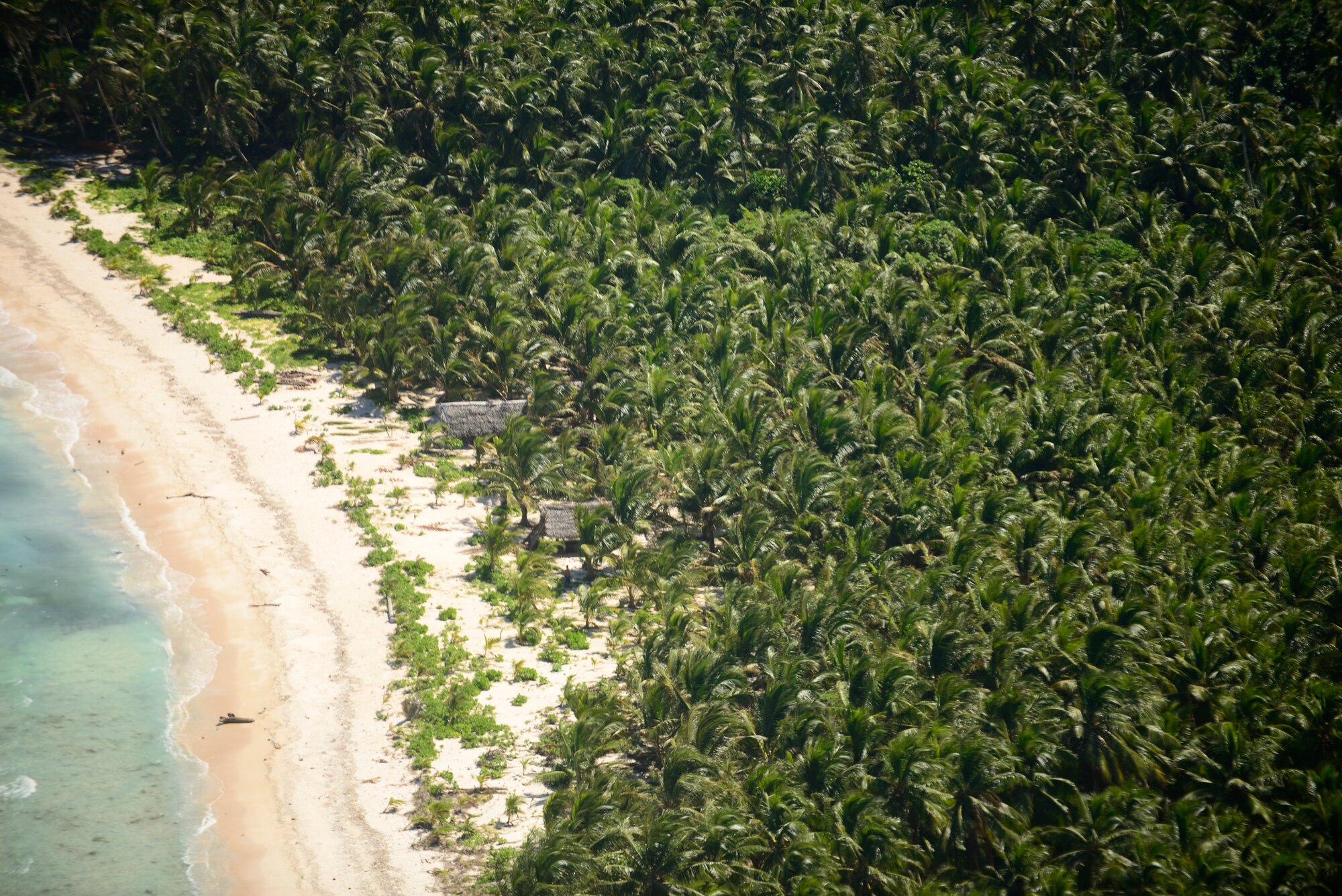 An aerial view of the island of Ifalik, Federated States of Micronesia, as a C-130H prepares to deliver an airdrop bundle containing relief supplies during Operation Christmas Drop Dec. 10, 2013. This year marks the 62nd year of Operation Christmas Drop, which began in 1952, making it the world's longest running airdrop mission. Every December, C-130 Hercules crews from the 374th Airlift Wing at Yokota Air Base, Japan, partner with the 36th Wing at Andersen Air Force Base, Guam, to airlift food, supplies and toys to islanders throughout Micronesia. (U.S. Air Force photo by 2nd Lt. Jake Bailey/Released)