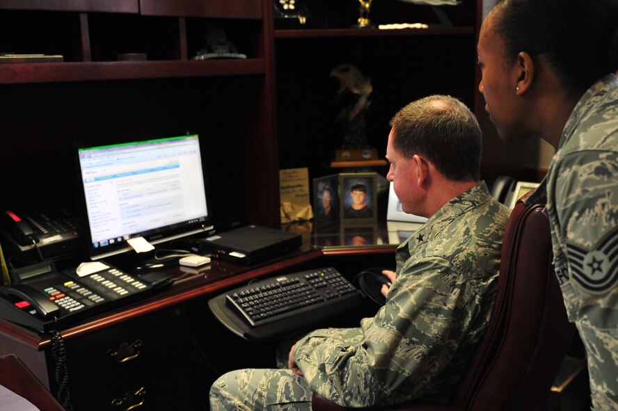 U.S. Air Force Brig. Gen. James Hecker, 18th Wing commander, navigates the MiCare website with the help of Tech. Sgt. Felita Ballard, 18th Medical Group Family Health flight NCO in charge, Kadena Air Base Japan, Dec. 6, 2013. After registering face-to-face, applicants finish the enrollment process online and are able to message their care team immediately. (U.S. Air Force photo by Staff Sgt. Rachelle Coleman)