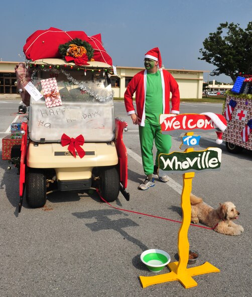 U.S. Air Force Senior Airman Nicholas Scott, 909th Aviation Resource Management flight, and his dog Charlie, wait next to the 909th Air Refueling Squadron's submission for the Deck out Santa's Sleigh contest, Kadena Air Base, Japan, Dec. 7, 2013. The 909th ARS won first place, followed by the 18th Security Forces Squadron and the 623rd Air Control Flight. (U.S. Air Force photo by Staff Sgt. Rachelle Coleman)