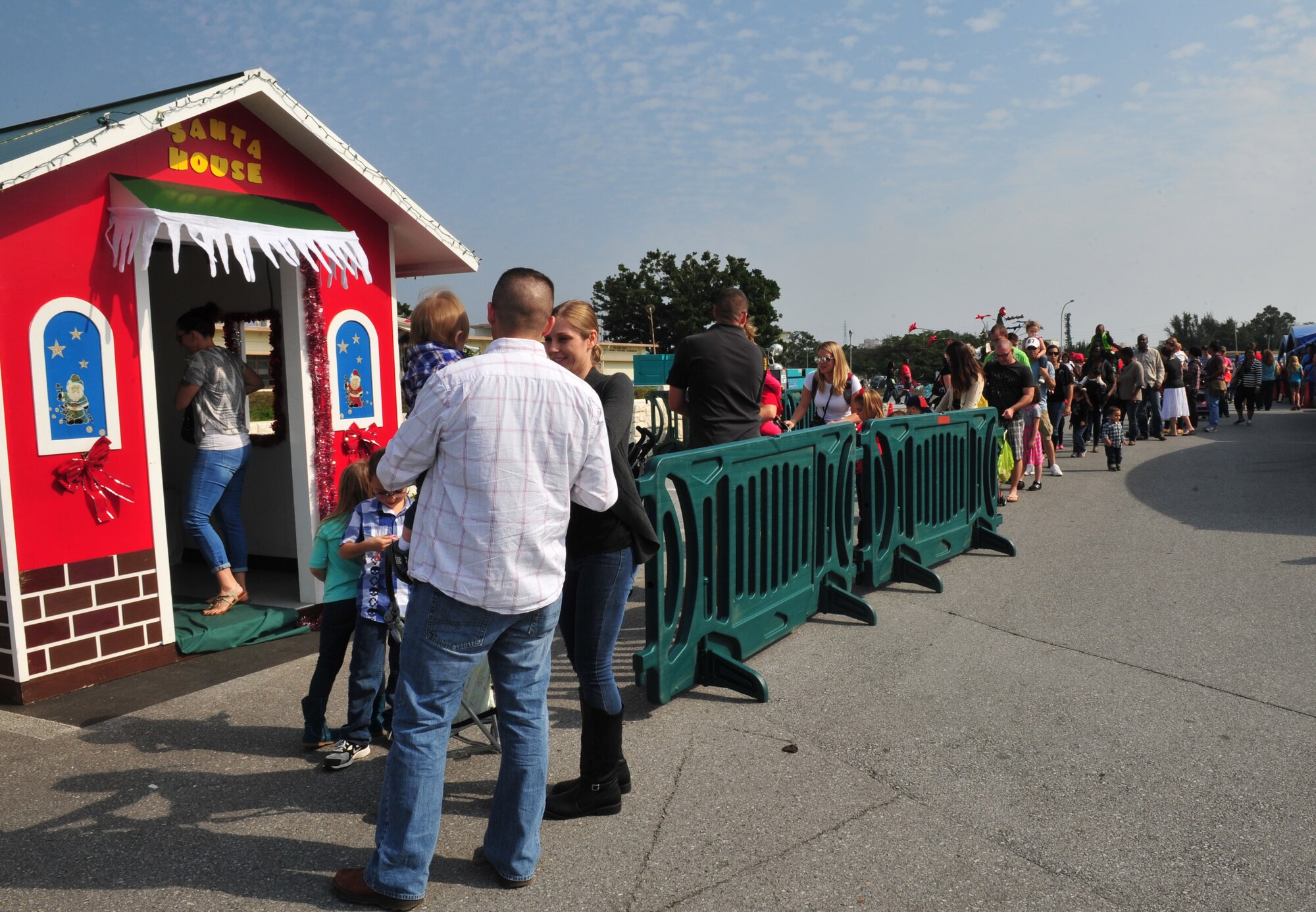 Families line up outside for the chance to take a picture with Santa Claus during Tinsel Town, Kadena Air Base, Japan, Dec. 7, 2013. Santa, Mrs. Claus, elves, and two snowmen visited with families during the holiday festivities. (U.S. Air Force photo by Staff Sgt. Rachelle Coleman)