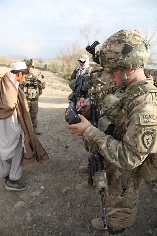 An International Security Assistance Force soldier on patrol in a remote forward location in Afghanistan uses a secure mobile handheld device. Photo courtesy of the Defense Advanced Research Projects Agency