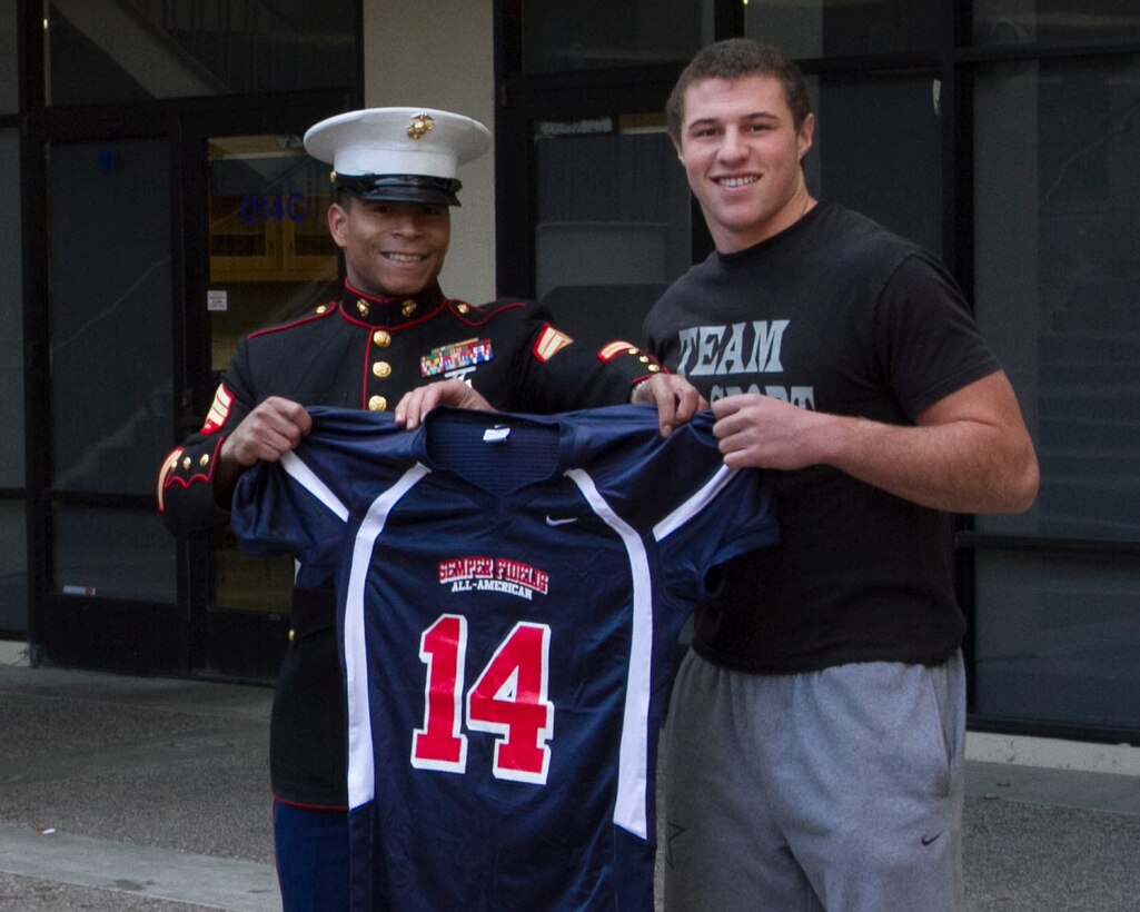 SAN JOSE – U.S. Marine Sgt. Enasio Alston, a recruiter from Recruiting Sub-Station San Jose North, presents a Semper Fidelis All-American Football Bowl jersey to Kyle Carta-Samuels, a senior and quarterback for Bellarmine College Preparatory, during a jersey presentation ceremony at the school here, Dec. 6. Carta-Samuels, a San Jose native, was selected for the bowl based on his efforts in the classroom, community and gridiron. Carta-Samuels will represent San Jose in the Semper Fidelis Bowl in January in Carlson, Calif. Alston is a native of Greensborough, N.C.