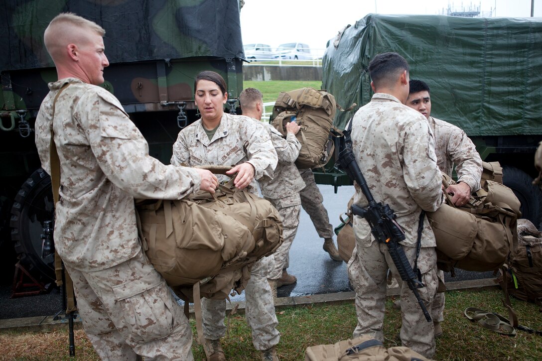 Marines help each other load their gear after returning from Afghanistan to Okinawa Dec. 9 at the Kadena Air Base passenger terminal. The Marines deployed for seven months to Camp Leatherneck, Helmand province, Afghanistan, to receive equipment from redeploying units, repair it as needed, and send it back to the U.S for redistribution throughout the Marine Corps. The Marines are with Retrograde and Redeployment, in support of Reset and Reconstitution Operations Group, Combat Logistics Battalion 4, Combat Logistics Regiment 3, 3rd Marine Logistics Group, III Marine Expeditionary Force. 