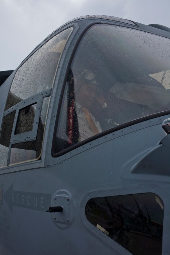 Hiromu Nakamaru places a cranial over his head while sitting in the cockpit of an MV-22B Osprey tiltrotor aircraft Dec. 9 during an orientation tour at Marine Corps Air Station Futenma. Nakamaru and other members of the Japan House of Representatives and Senate visited the air station to gain a better understanding of the Osprey. Nakamaru is a member of the Japan House of Representatives, and the Osprey is a part of Marine Medium Tiltrotor Squadron 262, Marine Aircraft Group 36, 1st Marine Aircraft Wing, III Marine Expeditionary Force.